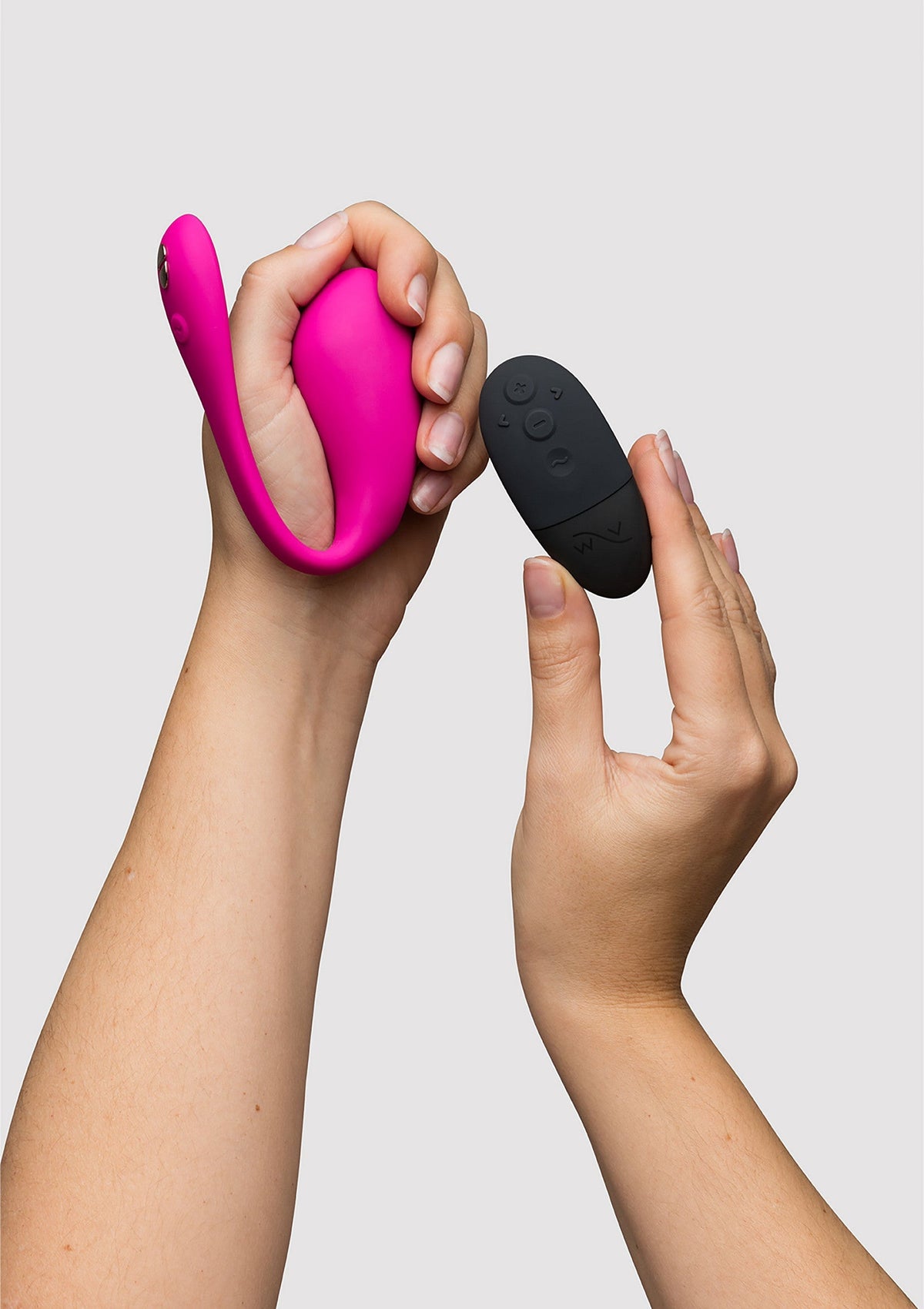 Vibromasseur rose avec télécommande noire pour le plaisir personnel.; Roze vibrator met zwarte afstandsbediening voor persoonlijk genot.; Pink vibrator with black remote control for personal pleasure.