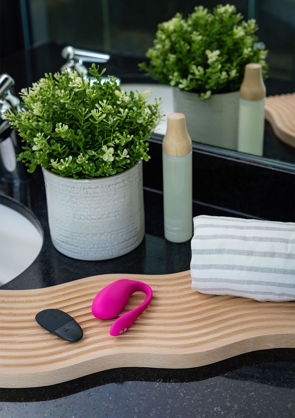 Accessoires de salle de bain: plante, plateau en bois, lotion et sextoy rose pour adulte.; Badkamer accessoires: plant, houten plank, lotion en roze seksspeeltje voor volwassenen.; Bathroom accessories: plant, wooden board, lotion and pink adult sex toy.