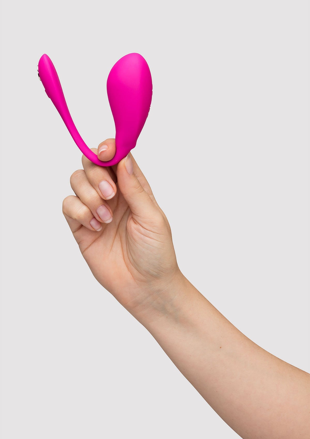 Masseur de clitoris rose élégant dans la main. Explorez le plaisir avec cet accessoire sensuel.; Stijlvolle roze clitorismassager in de hand. Ontdek plezier met dit sensuele accessoire.; Stylish pink clitoral massager in hand. Explore pleasure with this sensual accessory.