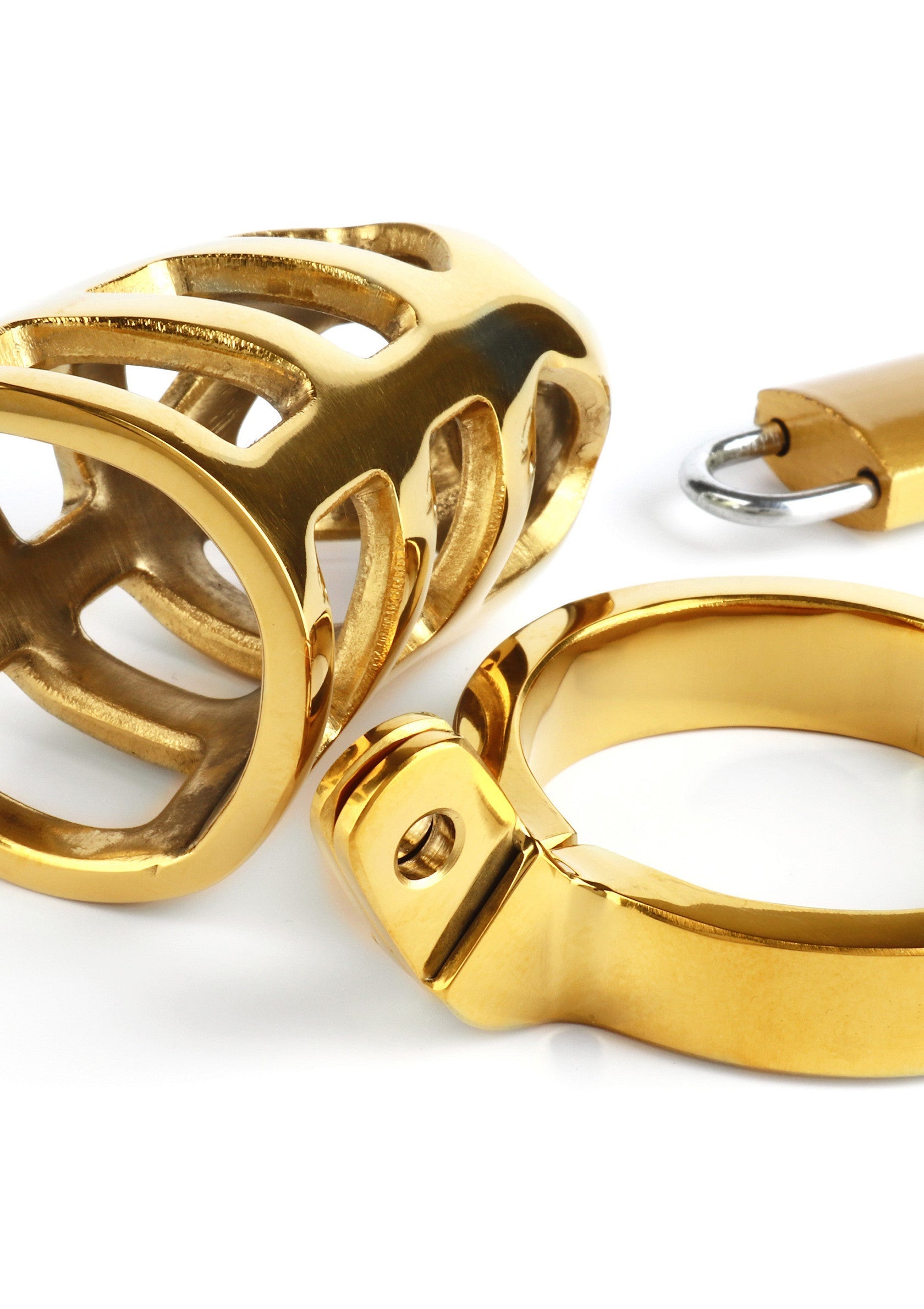 Cage de chasteté en or avec cadenas. Dispositif de chasteté masculin pour le plaisir BDSM et les jeux de rôle.; Gouden kuisheidskooi met hangslot. Mannelijk kuisheidstoestel voor BDSM-plezier en rollenspellen.; Gold chastity cage with padlock. Male chastity device for BDSM pleasure and roleplay.