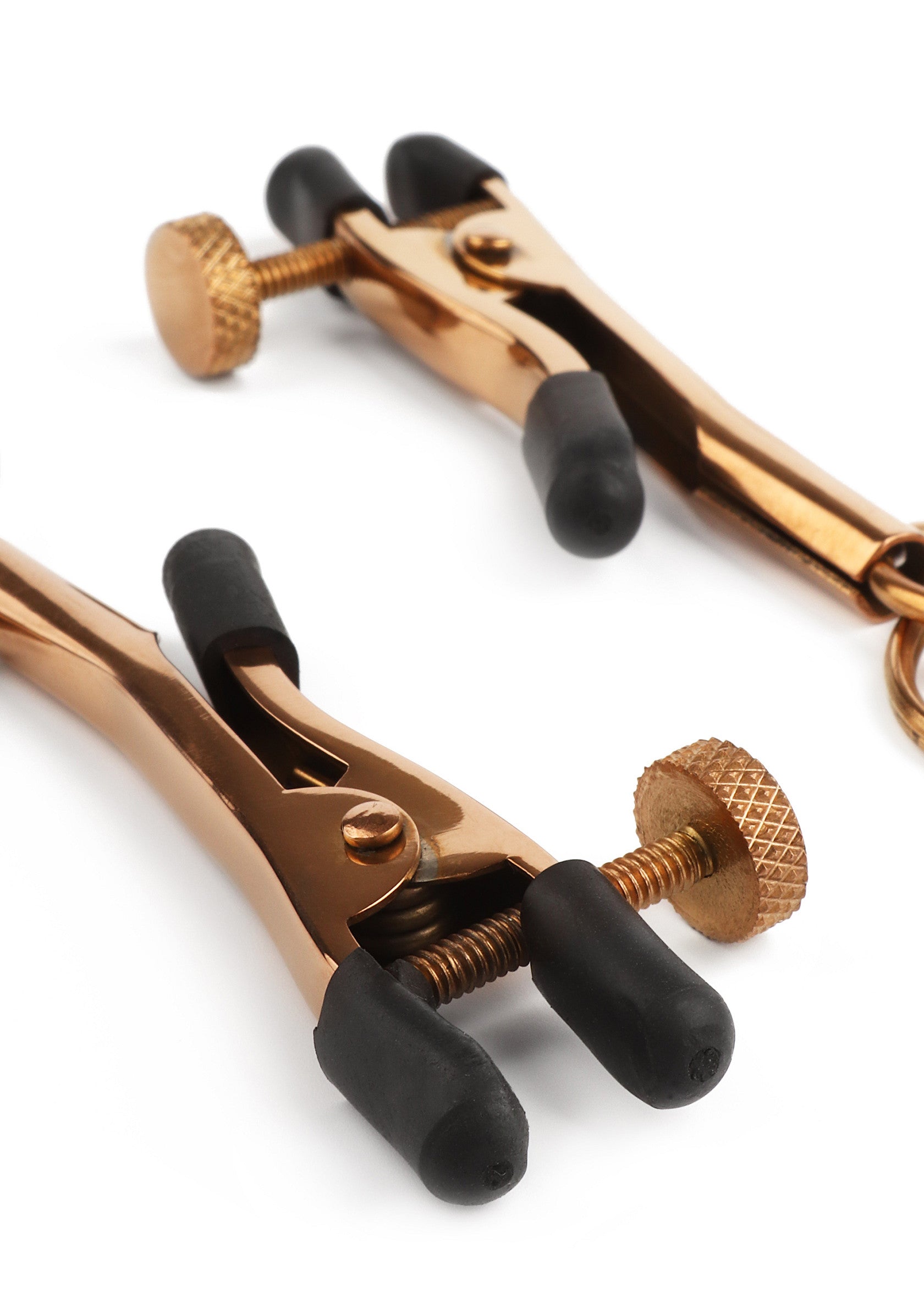 Pinces à tétons en métal doré réglables avec embouts en caoutchouc pour une sensation intense.; Verstelbare gouden metalen tepelklemmen met rubberen uiteinden voor een intense ervaring.; Adjustable gold metal nipple clamps with rubber tips for an intense sensation.