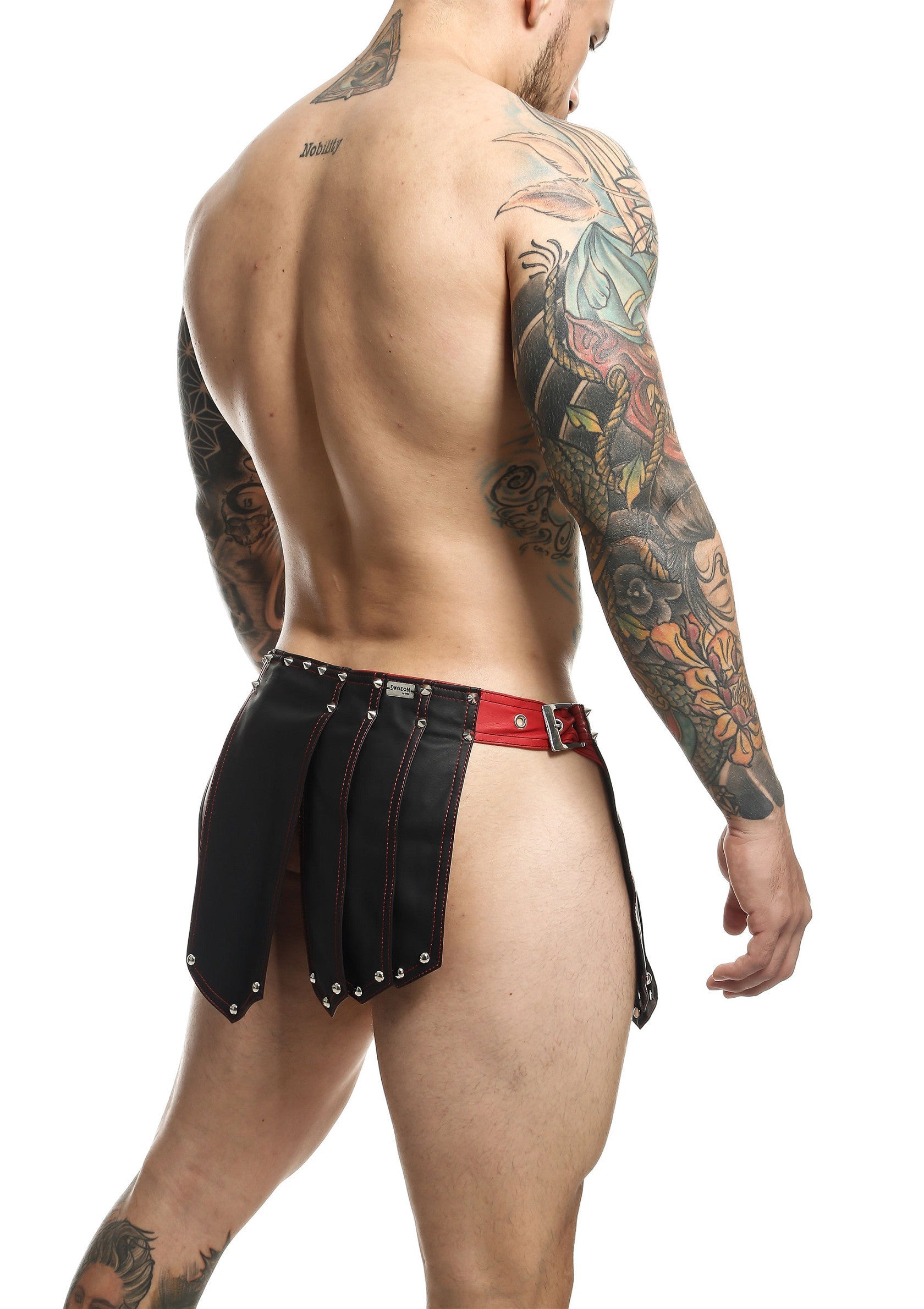 Jupe courte en cuir noir pour homme avec ceinture rouge. Accessoire de mode audacieux.; Korte zwarte leren rok voor mannen met rode riem. Gedurfde mode accessoire.; Men's short black leather skirt with red belt. Bold fashion accessory.