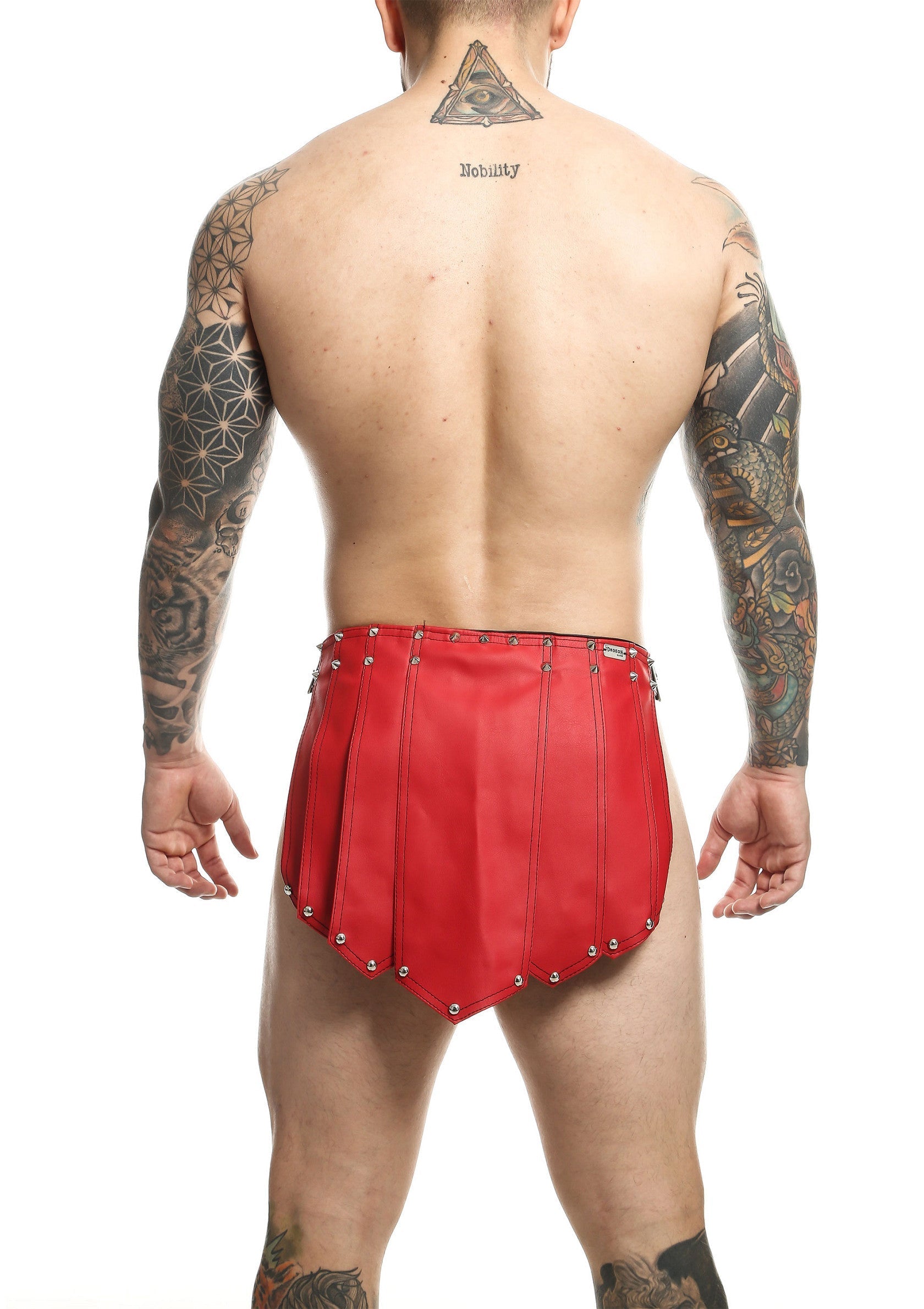 Jupe en cuir rouge pour homme. Lingerie fétichiste avec des rivets. Article mode homme.; Rode leren rok voor heren. Fetisj lingerie met klinknagels. Heren mode item.; Men's red leather skirt. Fetish lingerie with rivets. Men's fashion item.