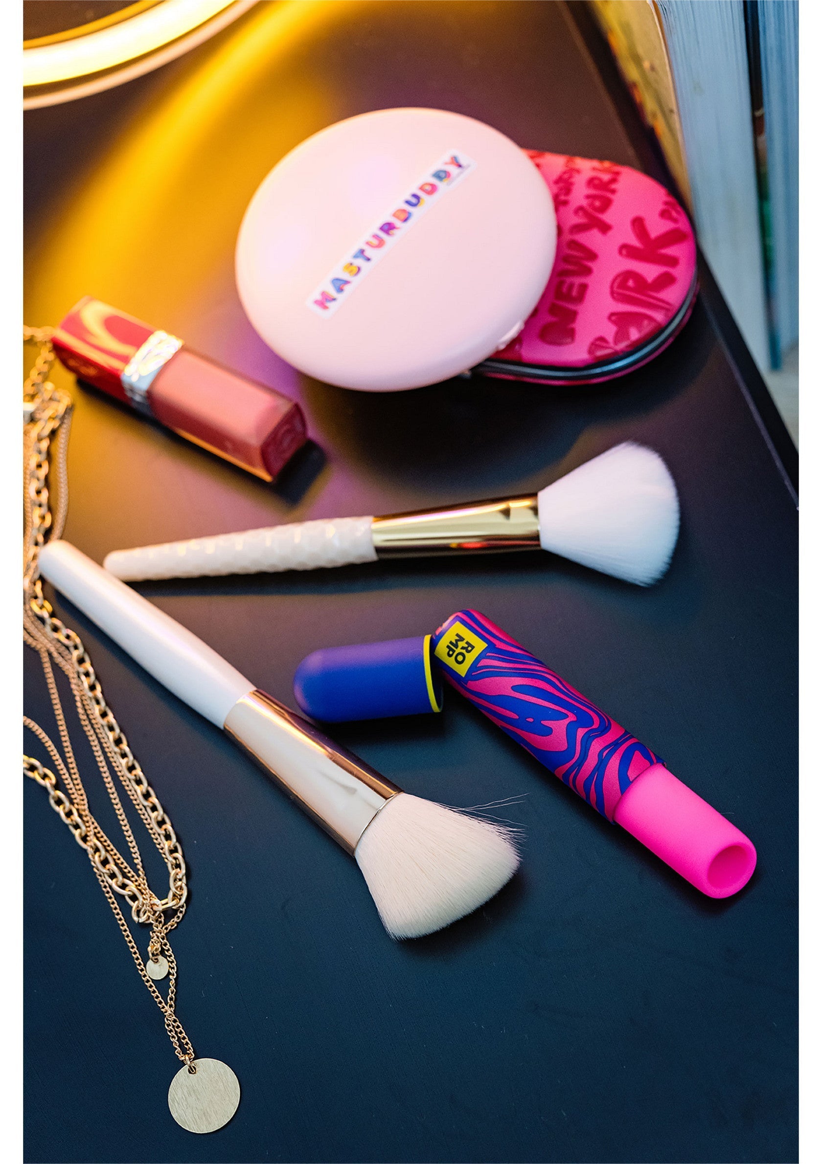 Ensemble de maquillage tendance : pinceaux, rouge à lèvres, poudre compacte et collier doré. Idéal pour un look complet et élégant.; Trendy make-up set: penselen, lippenstift, compact poeder en gouden ketting. Ideaal voor een complete en elegante look.; Trendy makeup set: brushes, lipstick, compact powder, and gold necklace. Ideal for a complete and stylish look.