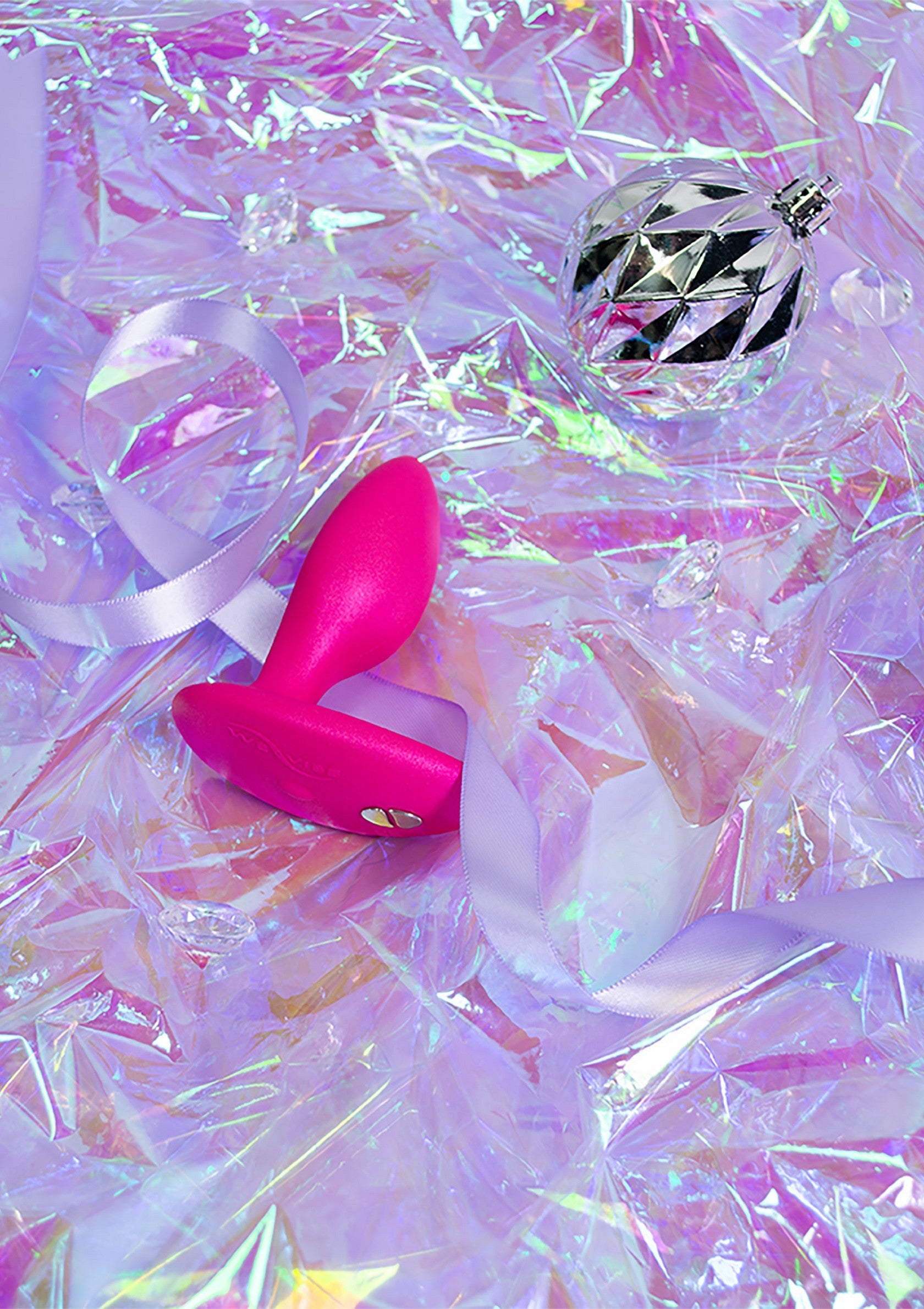 Plug anal rose et boule disco sur fond iridescent. Accessoires pour adultes pour des moments pétillants et amusants.; Roze anale plug en discobal op iriserende achtergrond. Volwassen accessoires voor sprankelende en leuke momenten.; Pink butt plug and disco ball on iridescent background. Adult accessories for sparkling and fun moments.