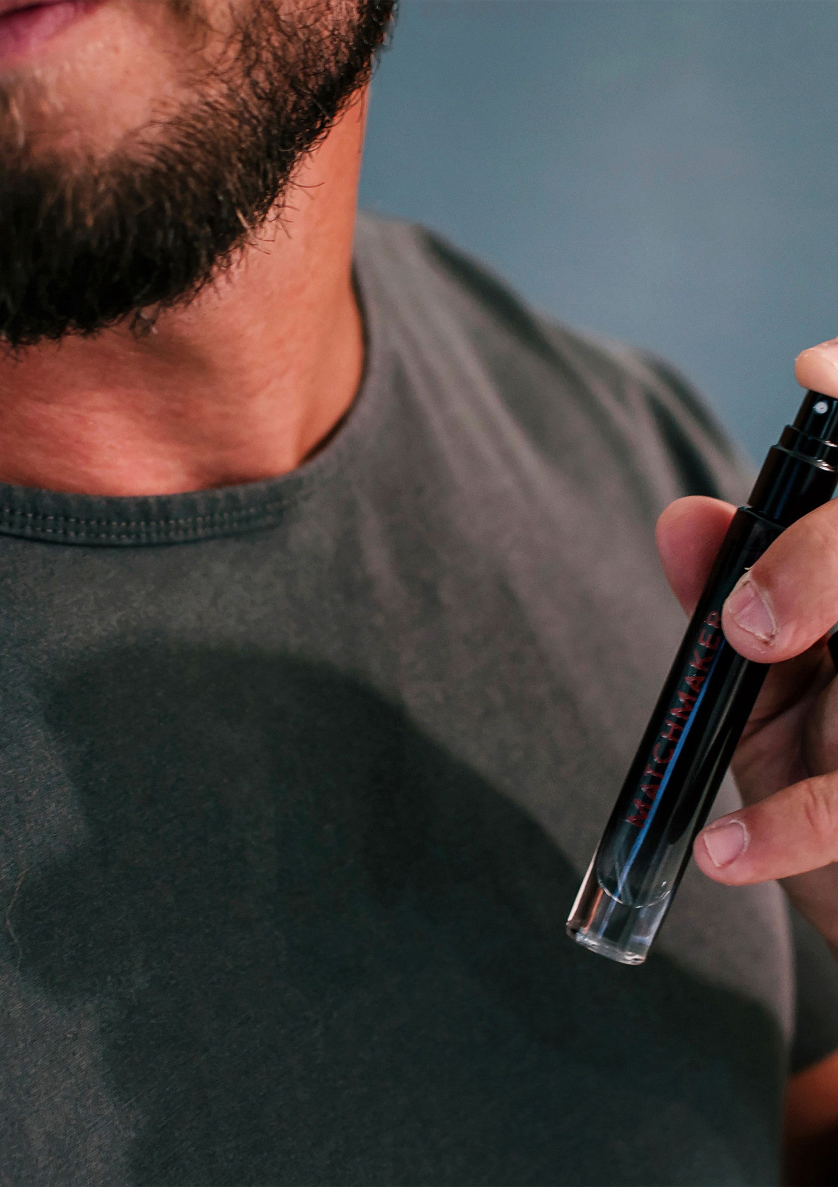 Homme appliquant un parfum de notre boutique. Découvrez nos fragrances uniques pour hommes.; Man die parfum uit onze winkel aanbrengt. Ontdek onze unieke herengeuren.; Man applying fragrance from our shop. Discover our unique scents for men.