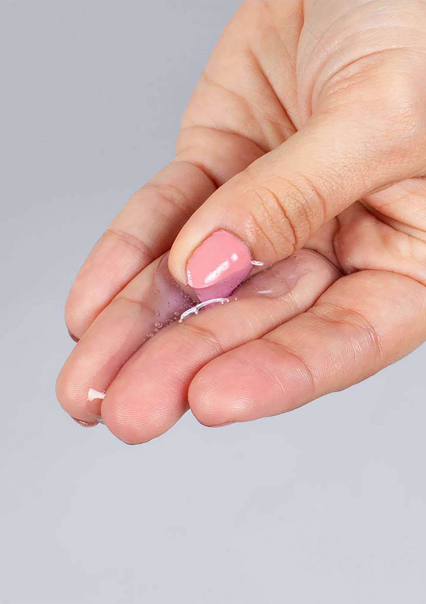 Main appliquant un produit de soin liquide. Idéal pour produits de beauté et bien-être.; Hand die een vloeibaar verzorgingsproduct aanbrengt. Ideaal voor schoonheids- en wellnessproducten.; Hand applying liquid skincare product. Ideal for beauty and wellness products.