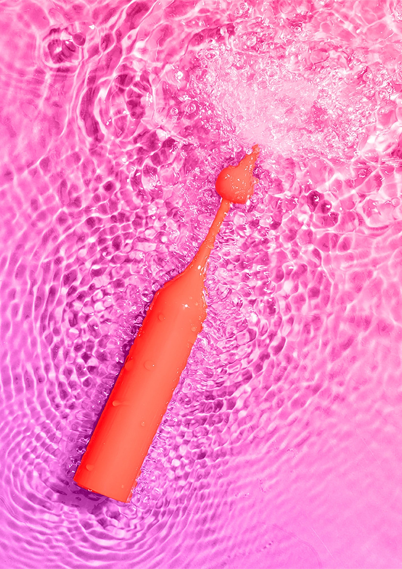 Jouet de bain orange dans l'eau rose, idéal pour s'amuser pendant le bain.; Oranje badspeeltje in roze water, perfect voor badplezier.; Orange bath toy in pink water, perfect for fun bath time.