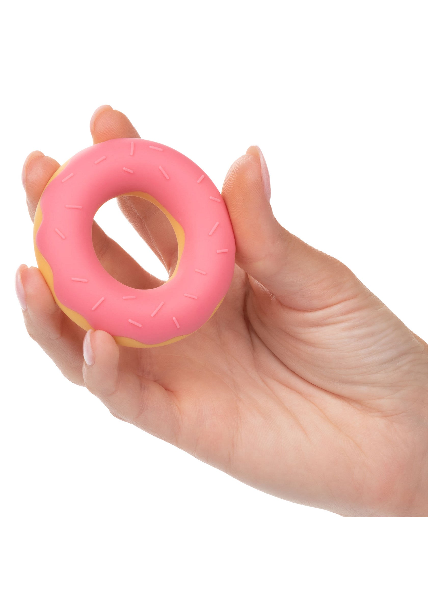 Main tenant un beignet rose décoratif. Idéal pour la décoration intérieure ou les cadeaux.; Hand houdt een decoratieve roze donut vast. Ideaal voor interieurdecoratie of cadeaus.; Hand holding decorative pink donut. Great for home decor or gifts.