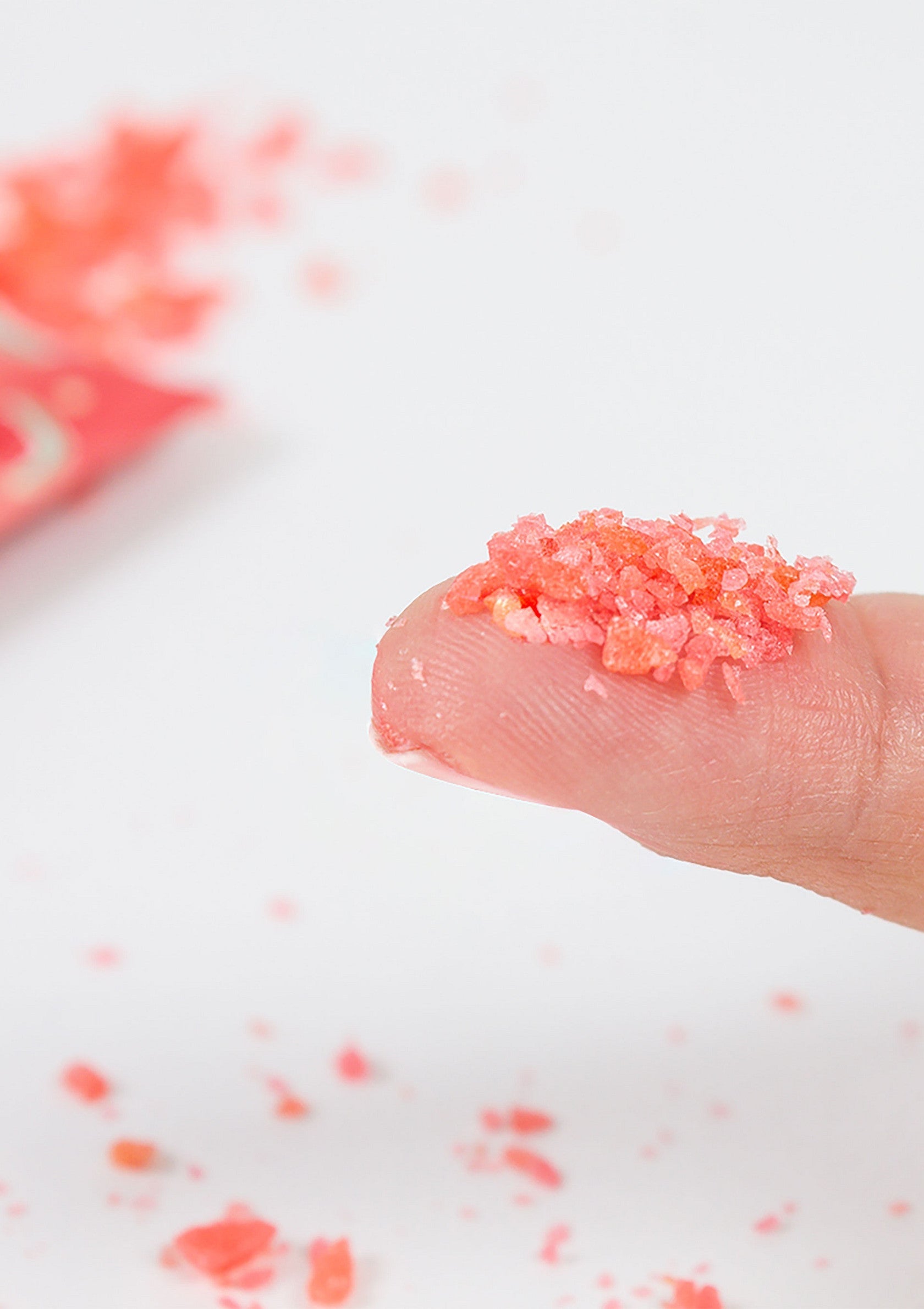 Bonbons pétillants roses sur le doigt, explosion de saveur garantie. Découvrez nos douceurs acidulées!; Roze knettersnoep op een vinger, gegarandeerde smaakexplosie. Ontdek onze zure lekkernijen!; Pink popping candy on a finger, a guaranteed flavor explosion. Discover our sour sweets!