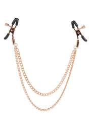 Pinces à tétons dorées avec chaînes. Accessoires coquins pour pimenter votre vie amoureuse.; Gouden tepelklemmen met kettingen. Speelse accessoires om uw liefdesleven mee op te fleuren.; Gold nipple clamps with chains. Playful accessories to spice up your love life.