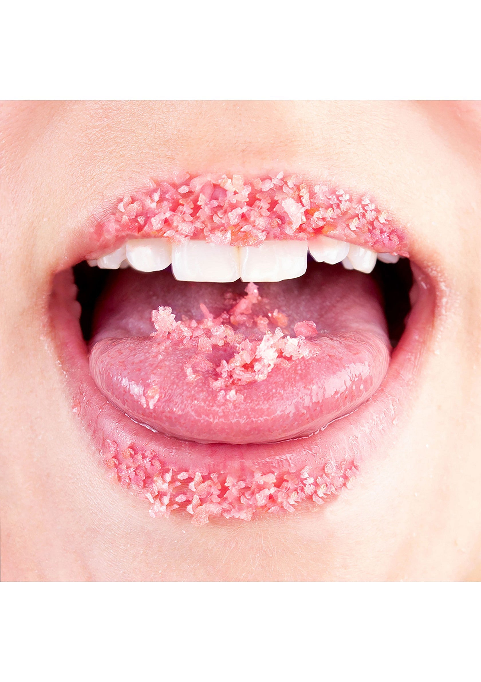Lèvres et langue couvertes de cristaux roses. Exfoliant pour des lèvres douces et pulpeuses.; Lippen en tong bedekt met roze kristallen. Scrub voor zachte, volle lippen.; Lips and tongue covered in pink crystals. Lip scrub for soft, plump lips.