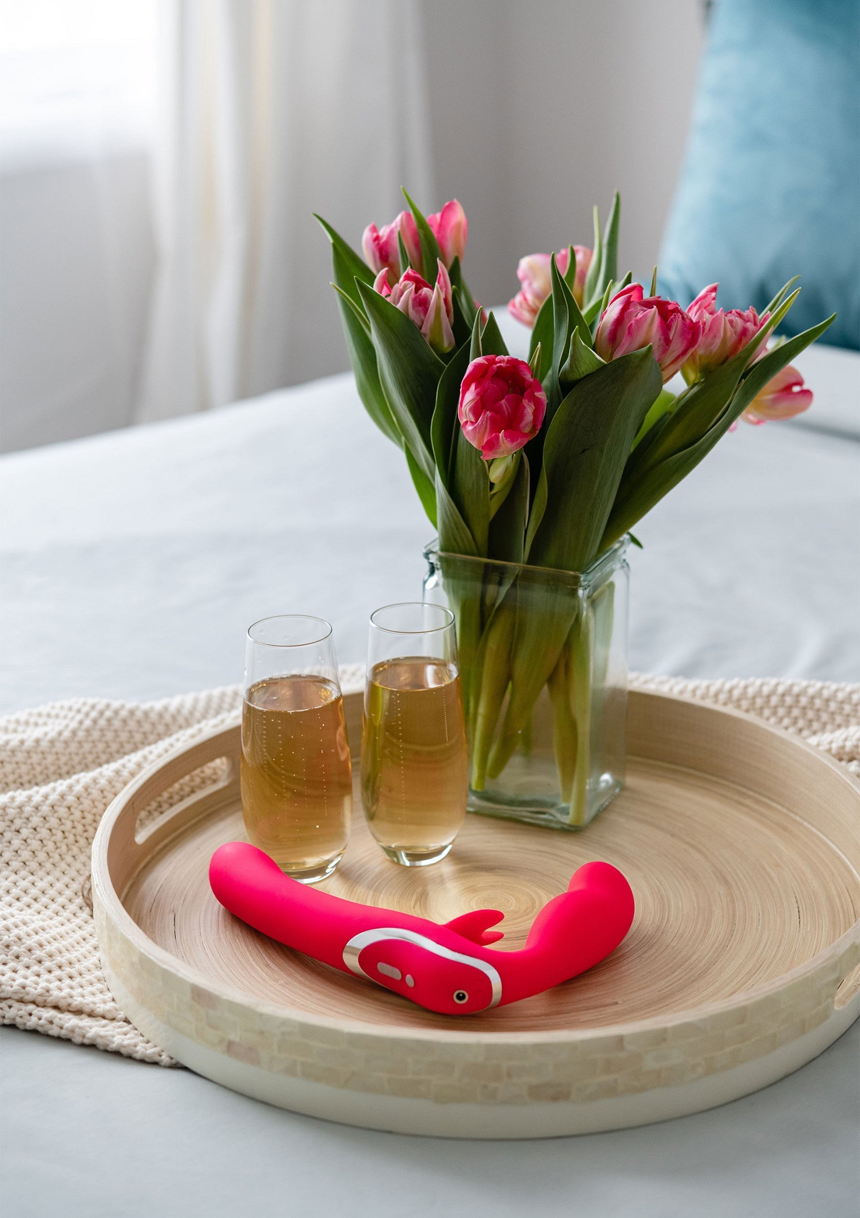 Vibromasseur rose élégant sur un plateau avec des tulipes et du champagne. Plaisir et détente garantis!; Stijlvolle roze vibrator op een dienblad met tulpen en champagne. Gegarandeerd plezier en ontspanning!; Stylish pink vibrator on a tray with tulips and champagne. Guaranteed pleasure and relaxation!