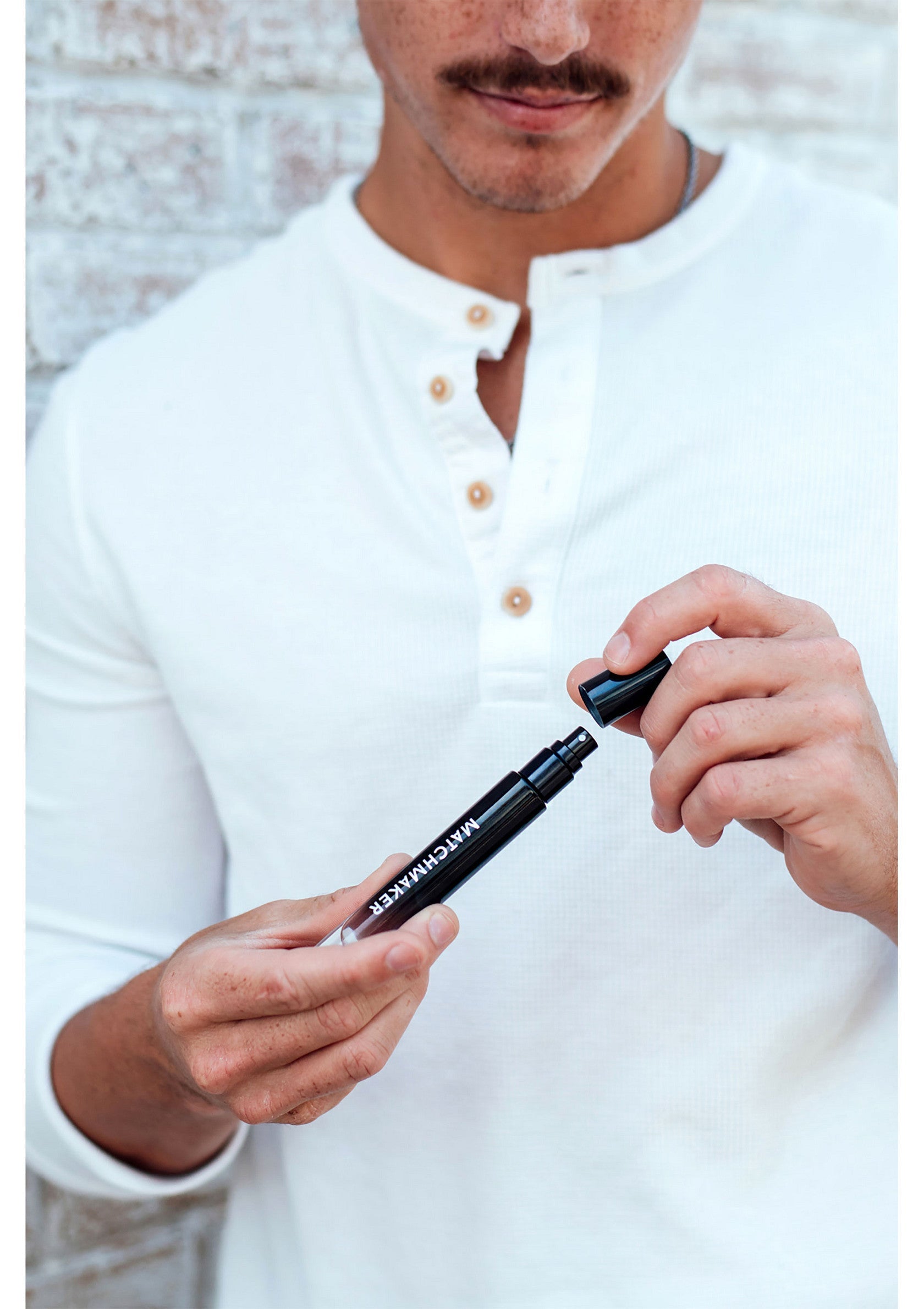 Homme ouvrant un marqueur noir "Matchmaker" sur un fond de briques. Accessoire de beauté pour hommes.; Man opent een zwarte "Matchmaker" marker tegen een bakstenen achtergrond. Heren beauty accessoire.; Man opening a black "Matchmaker" marker against a brick background. Men's beauty accessory.