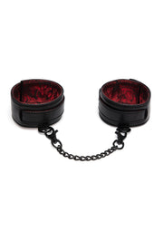 Menottes en cuir noir avec doublure rouge et chaîne en métal. Accessoire de bondage.; Zwarte lederen handboeien met rode voering en metalen ketting. Bondage accessoire.; Black leather cuffs with red lining and metal chain. Bondage accessory.