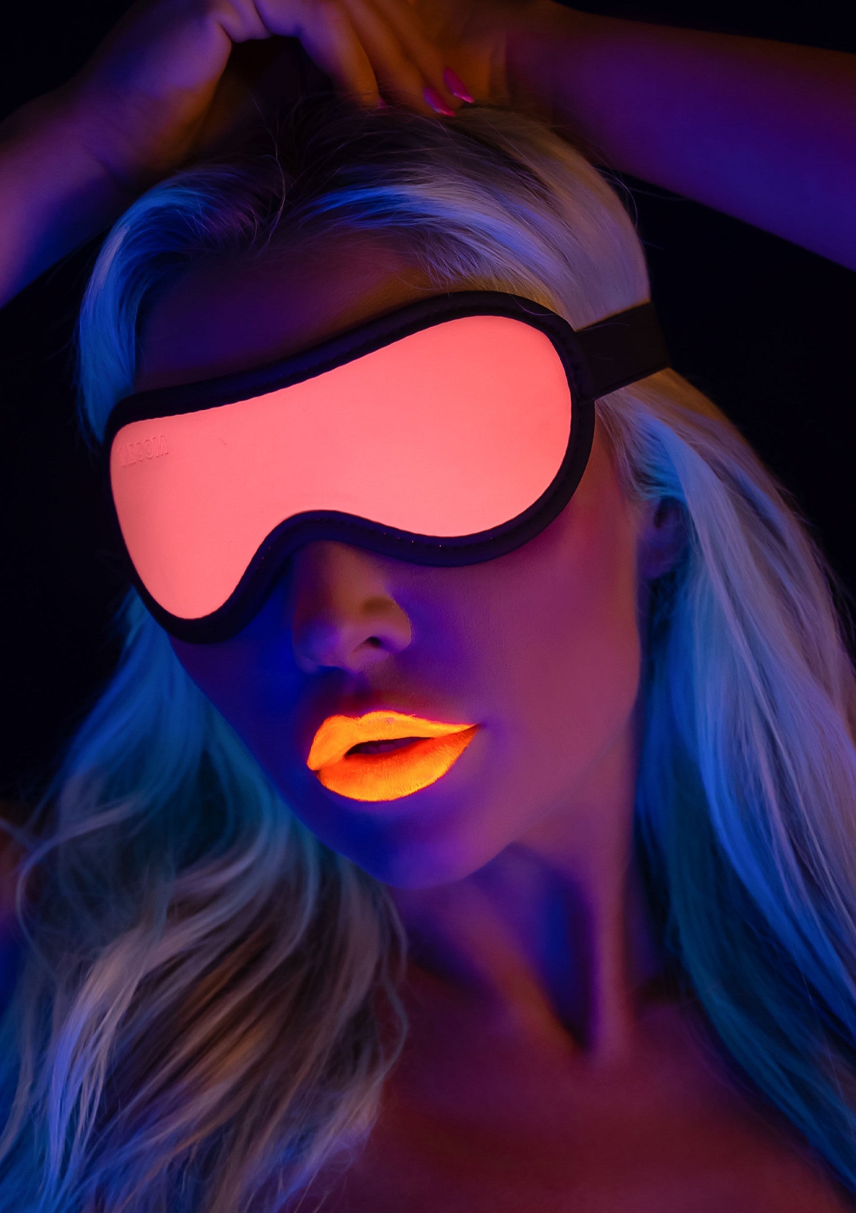 Femme portant un masque pour les yeux, lèvres orange fluorescentes, ambiance néon. Idéal pour se détendre ou se démarquer en soirée.; Vrouw met oogmasker, oranje fluorescerende lippen, neon sfeer. Ideaal om te ontspannen of op te vallen tijdens een avondje uit.; Woman wearing an eye mask, fluorescent orange lips, neon vibe. Ideal for relaxation or standing out during a night out.