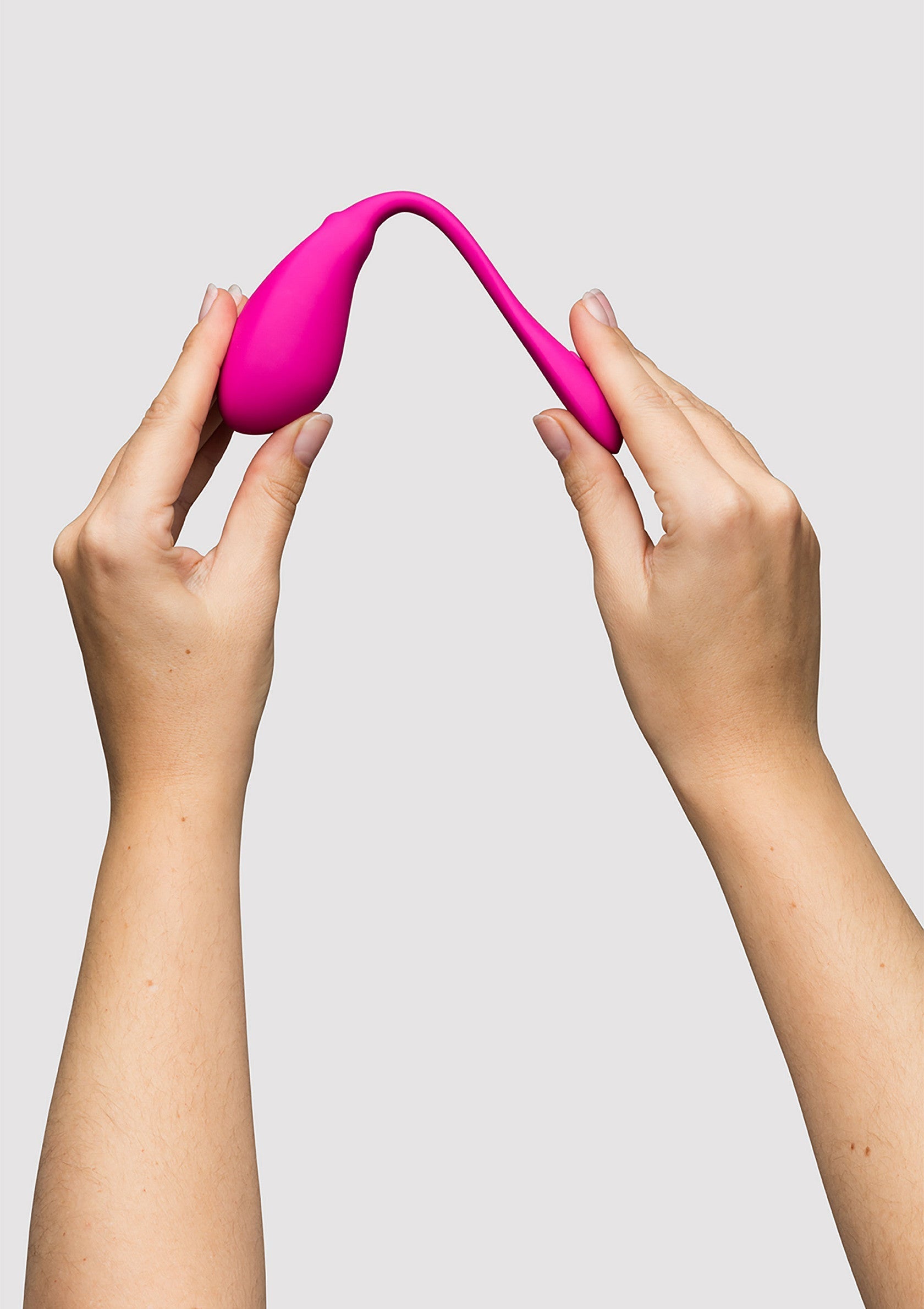 Mains tenant un sextoy vibrant rose. Plaisir et bien-être intime garantis.; Handen houden een roze, vibrerend seksspeeltje vast. Gegarandeerd genot en intiem welzijn.; Hands holding a pink, vibrating sex toy. Guaranteed pleasure and intimate well-being.