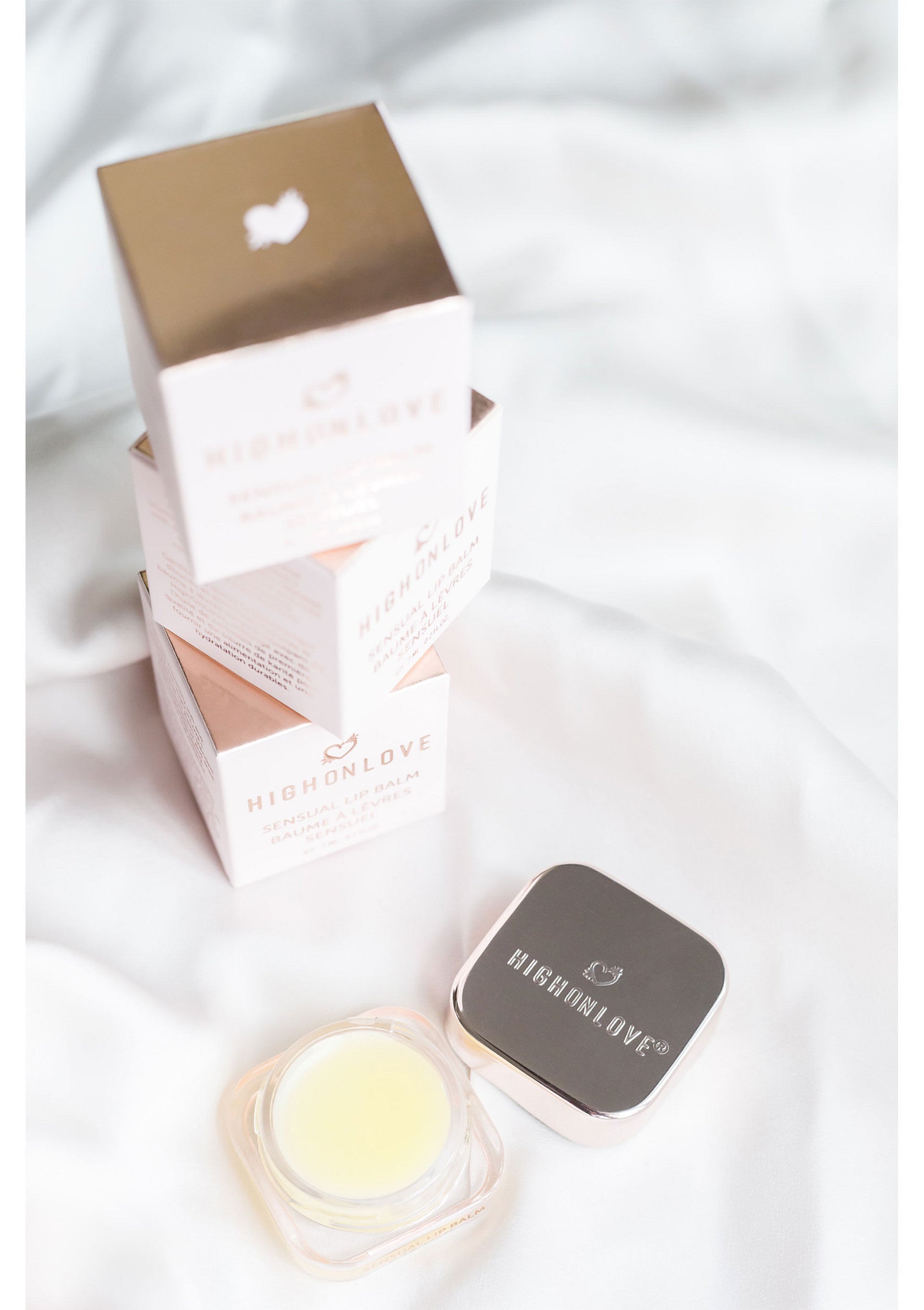 Coffrets et baume à lèvres HighOnLove sur un tissu blanc, pour une peau douce et hydratée. Découvrez le luxe!; HighOnLove dozen en lippenbalsem op witte stof, voor een zachte en gehydrateerde huid. Ontdek luxe!; HighOnLove boxes & lip balm on white fabric, for soft & hydrated skin. Discover luxury!