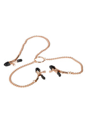 Pinces à tétons dorées avec chaîne pour un plaisir intense.; Gouden tepelklemmen met ketting voor intense ervaringen.; Gold nipple clamps with chain for intense pleasure.