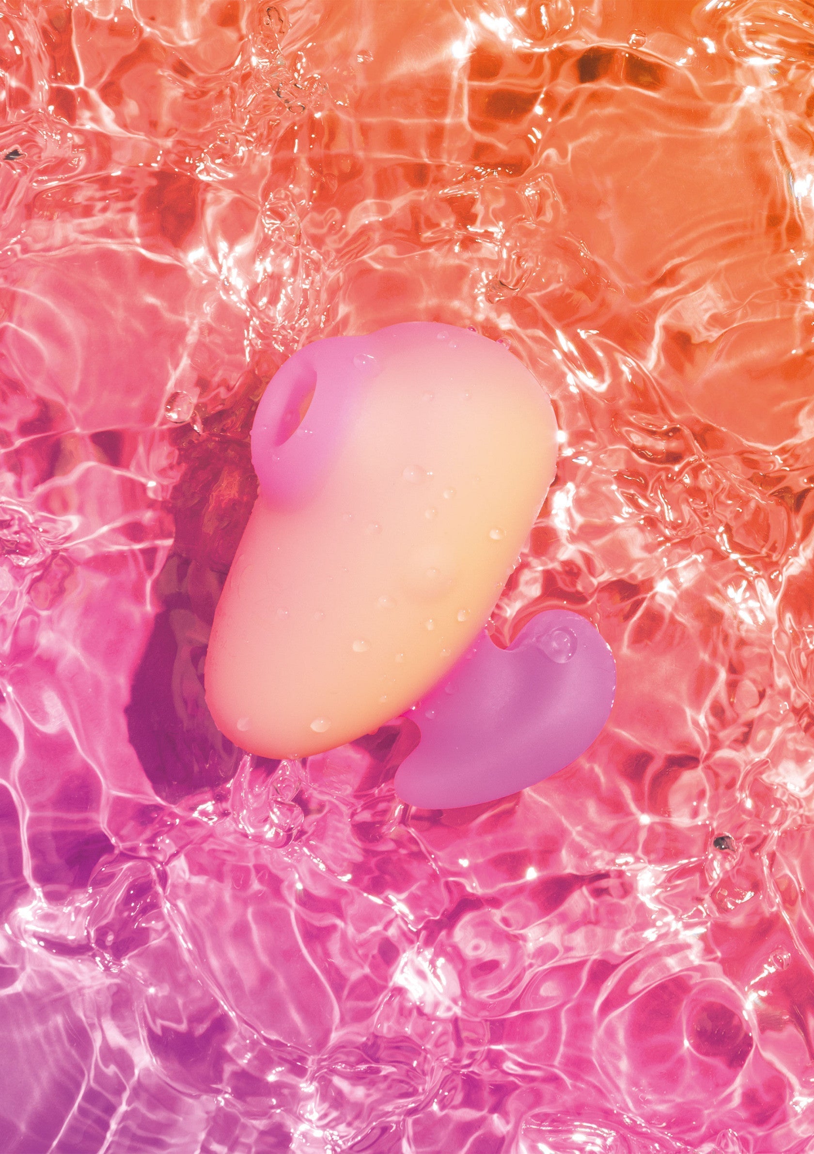 Jouet pour adultes dans l'eau avec des nuances d'orange et de rose pour le plaisir et l'intimité.; Volwassen speeltje in water met tinten oranje en roze voor plezier en intimiteit.; Adult toy in water with shades of orange and pink for pleasure and intimacy.
