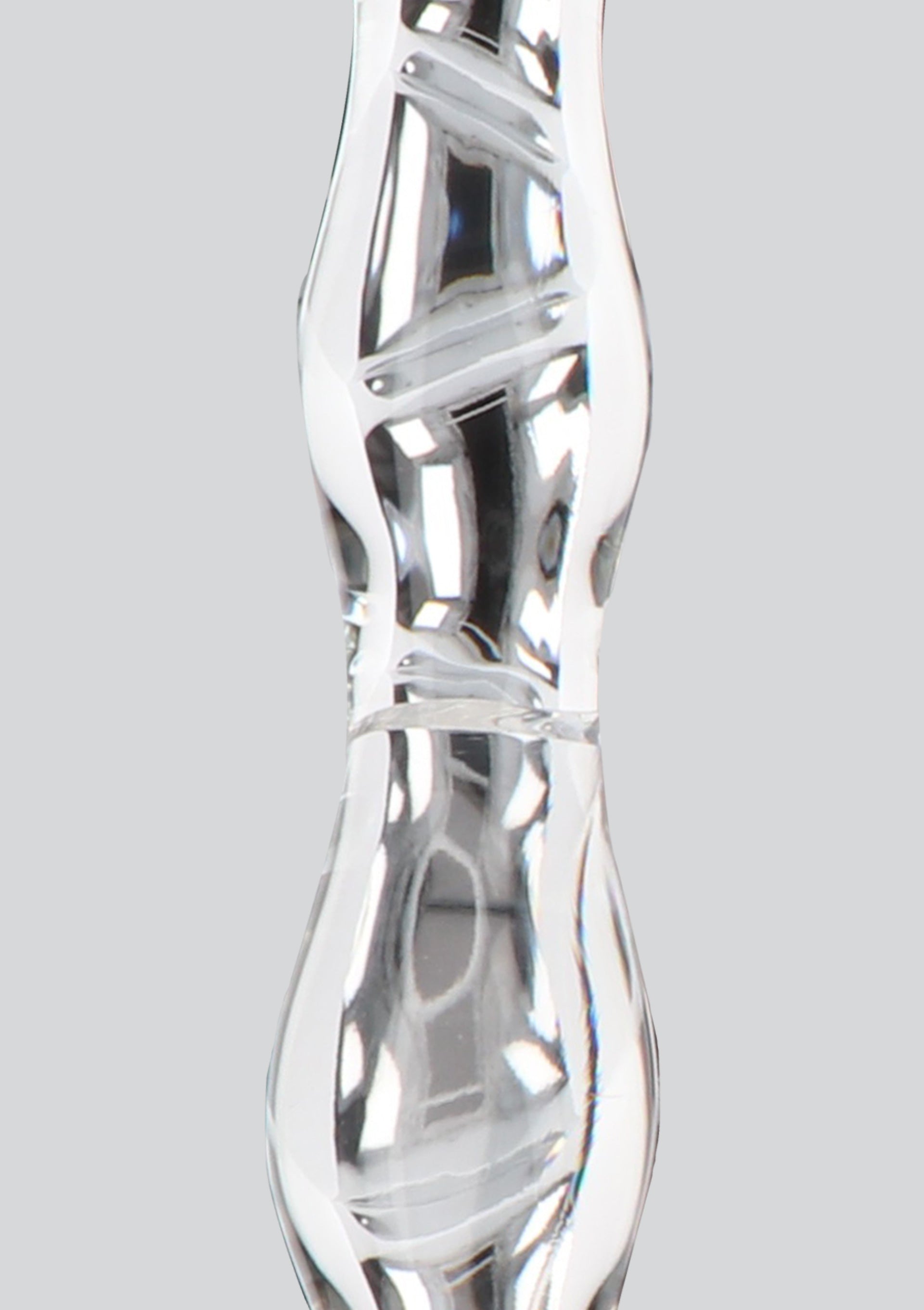 Détail d'un vase en verre transparent avec des motifs tourbillonnants. Élégant et moderne pour toute décoration.; Detail van een transparante glazen vaas met wervelpatronen. Elegant en modern voor elke decoratie.; Close-up of a clear glass vase with swirl designs. Elegant and modern for any decor.