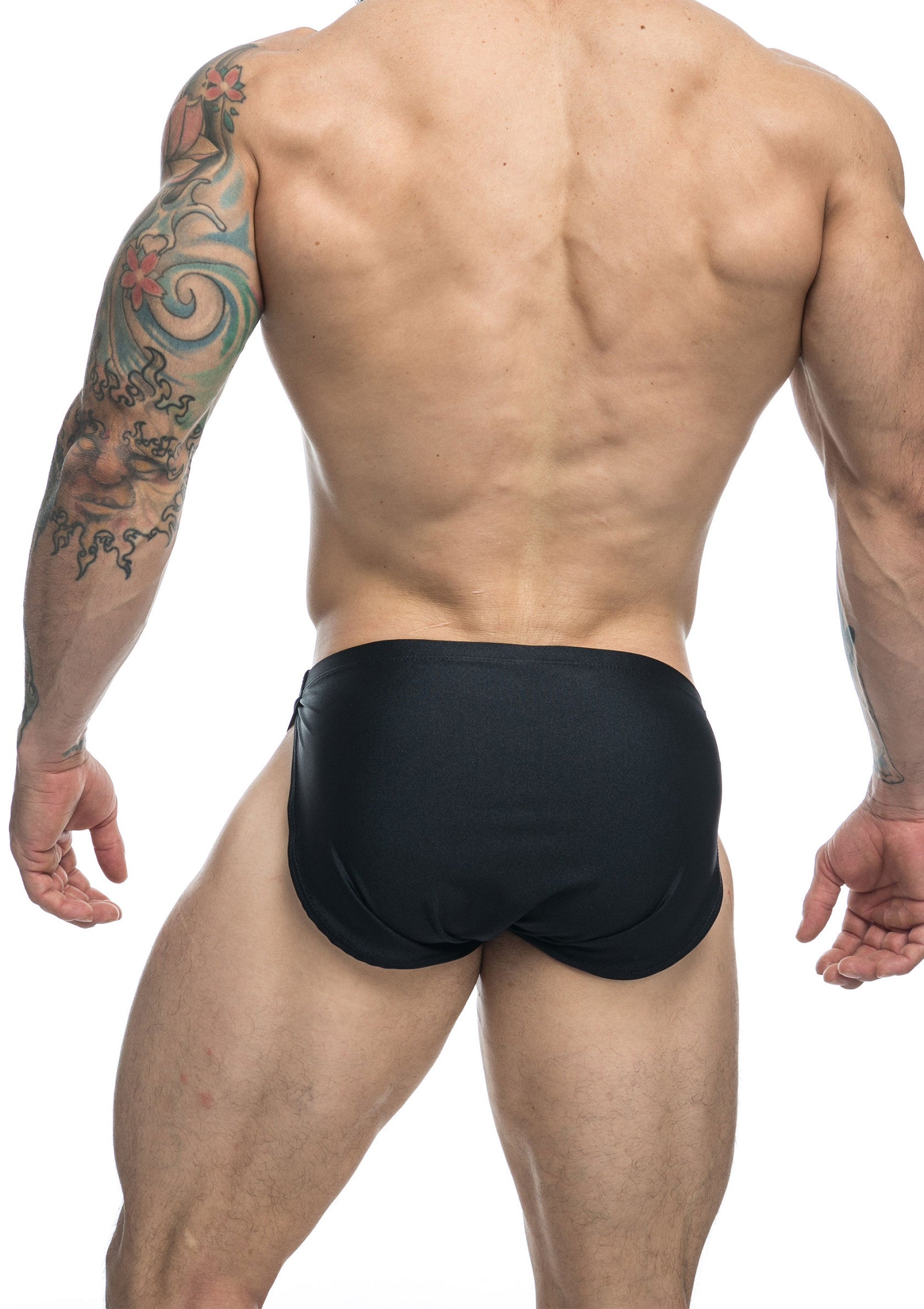 Slip de bain noir pour homme, coupe athlétique, dos et tatouage visible.; Zwarte zwemslip voor heren, atletische pasvorm, rug en tatoeage zichtbaar.; Men's black swim briefs, athletic fit, back and tattoo visible.