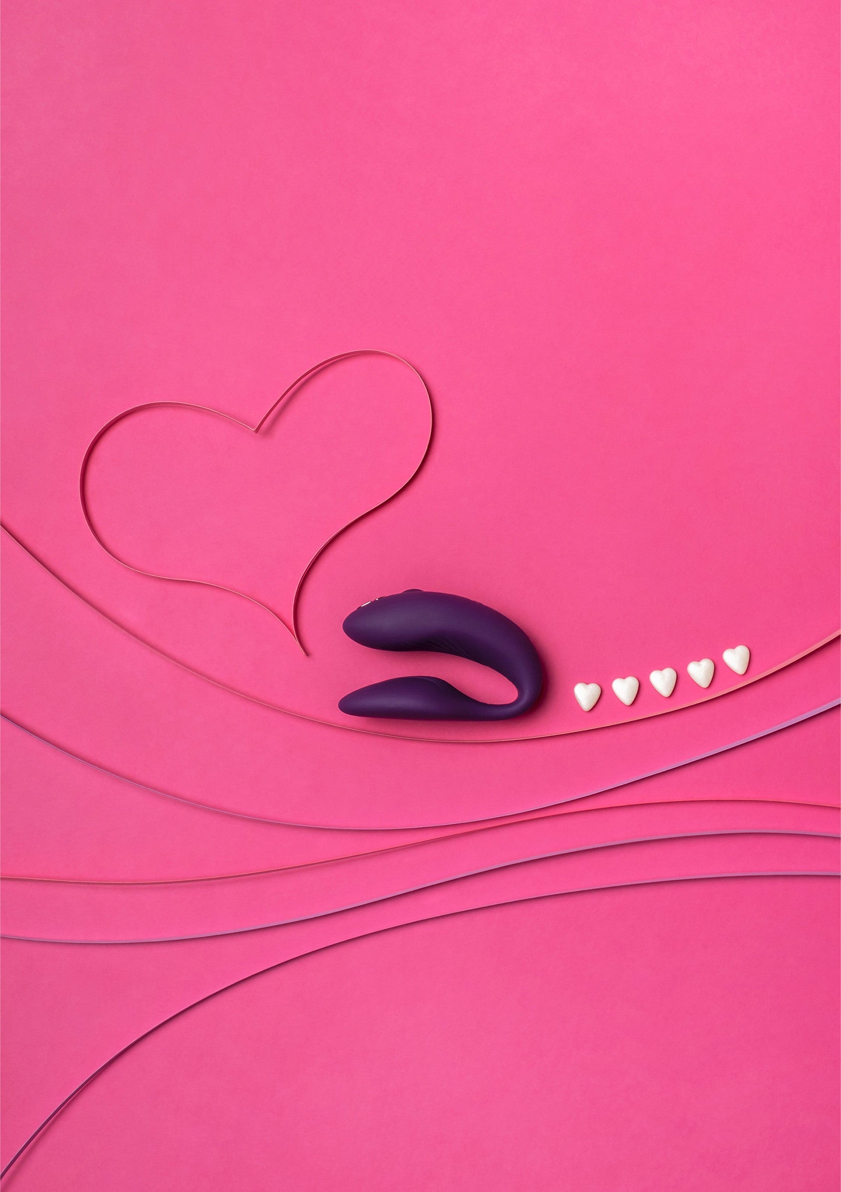 Vibrateur violet sur fond rose avec coeurs, pour pimenter votre vie amoureuse. Découvrez notre sélection coquine !; Paarse vibrator op roze achtergrond met hartjes. Ontdek onze selectie spannende speeltjes voor volwassenen!; Purple vibrator on a pink background with hearts. Spice up your love life! Shop our selection of adult toys.