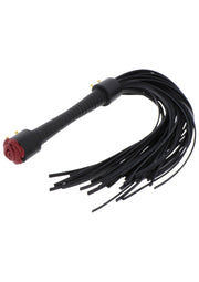 Cravache noire avec détail de rose rouge. Accessoire de jeu pour adultes pour pimenter votre vie amoureuse.; Zwarte zweep met rode roos detail. Volwassen speelgoedaccessoire om je liefdesleven mee op te fleuren.; Black flogger with red rose detail. Adult toy accessory to spice up your love life.