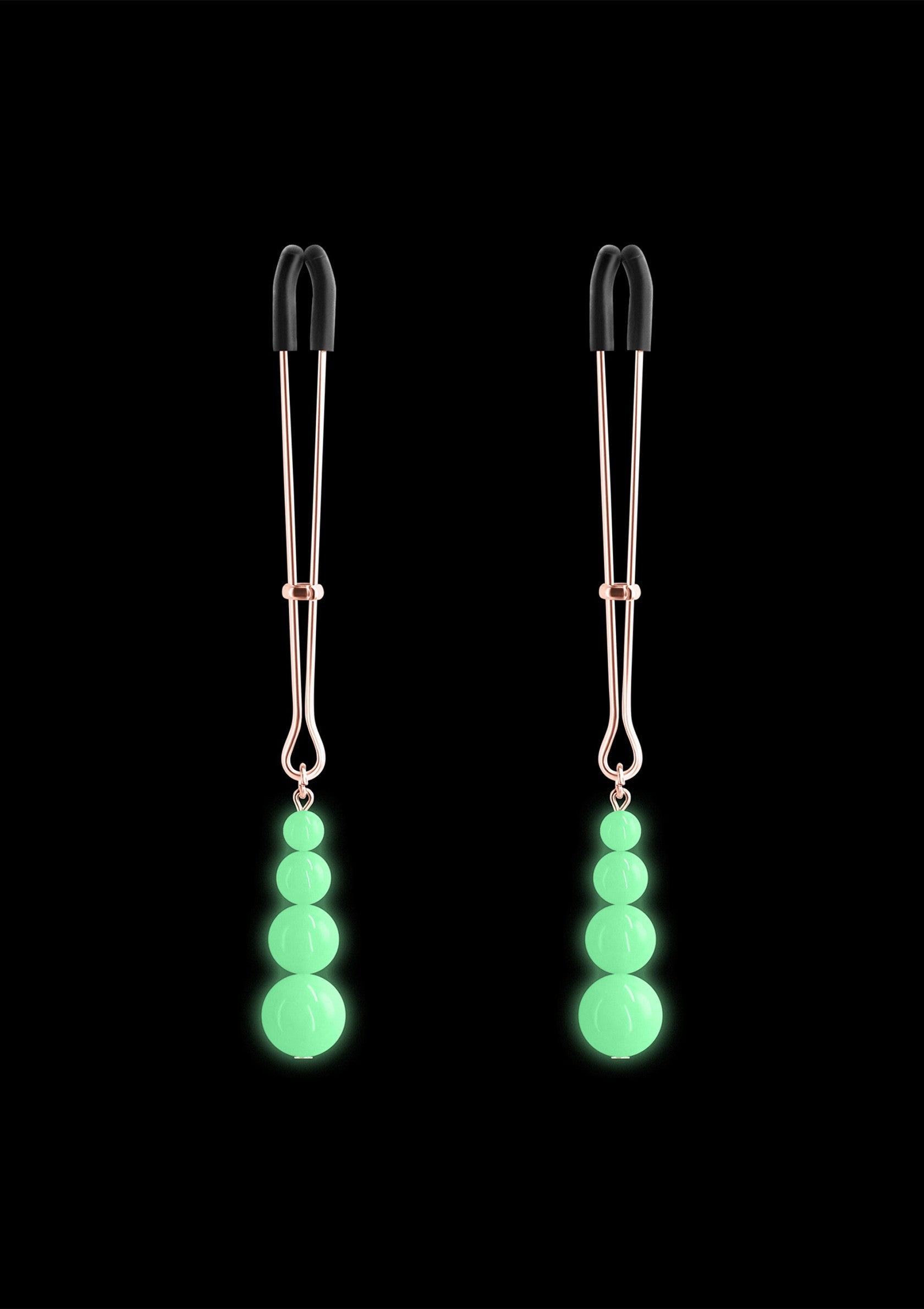 Pinces à tétons avec perles lumineuses. Accessoire érotique original pour pimenter vos jeux coquins.; Tepelklemmen met lichtgevende kralen. Origineel erotisch accessoire om je stout spel op te fleuren.; Nipple clamps with glow-in-the-dark beads. An original erotic accessory to spice up your naughty games.