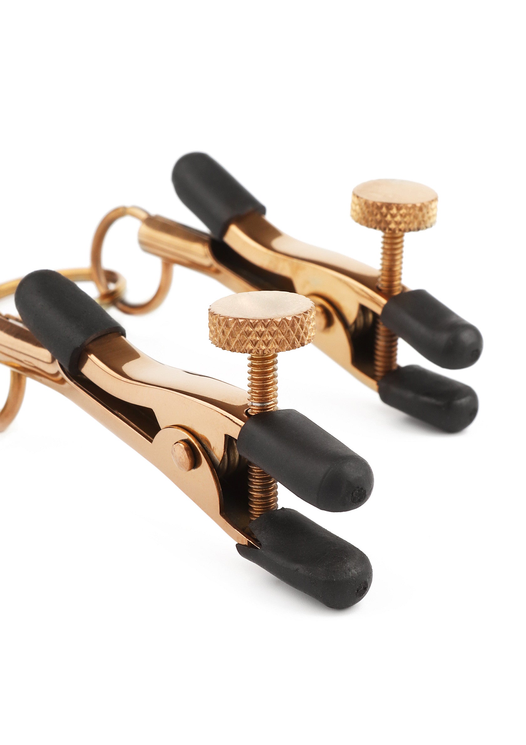 Pinces à tétons dorées avec embouts en caoutchouc pour un plaisir intense.; Gouden tepelklemmen met rubberen uiteinden voor intense prikkels.; Gold nipple clamps with rubber tips for intense stimulation and play.