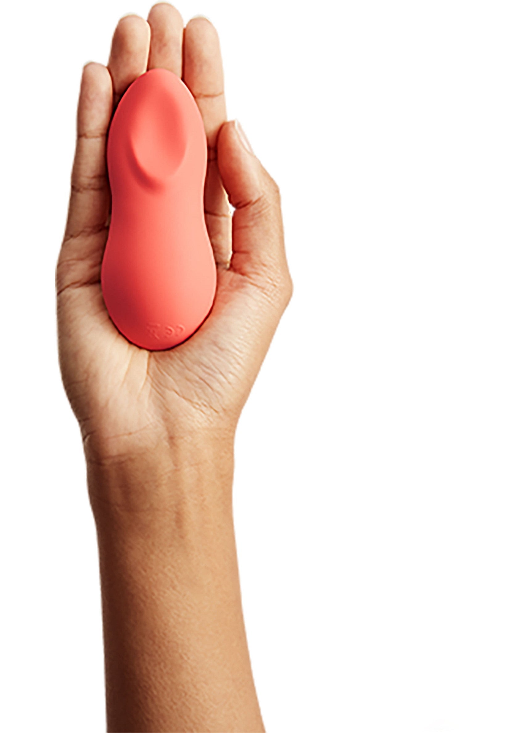 Masseur personnel corail en main, pour une expérience intime et relaxante. Plaisir discret.; Koraalkleurige persoonlijke stimulator in de hand, voor een intieme en ontspannende ervaring. Discreet plezier.; Coral personal massager held in hand, for an intimate and relaxing experience. Discreet pleasure.