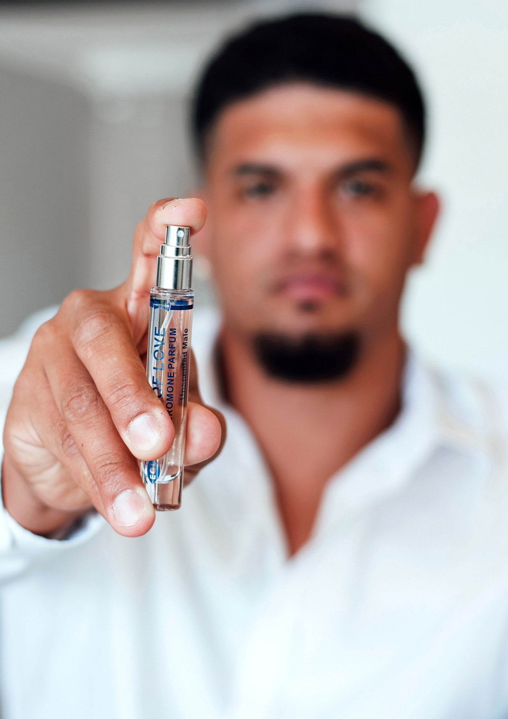 Homme présentant un parfum. Découvrez nos parfums pour hommes et trouvez votre senteur signature.; Man die parfum vasthoudt. Ontdek onze herenparfums en vind uw kenmerkende geur.; Man holding a perfume bottle. Shop our men's cologne and find your signature scent.