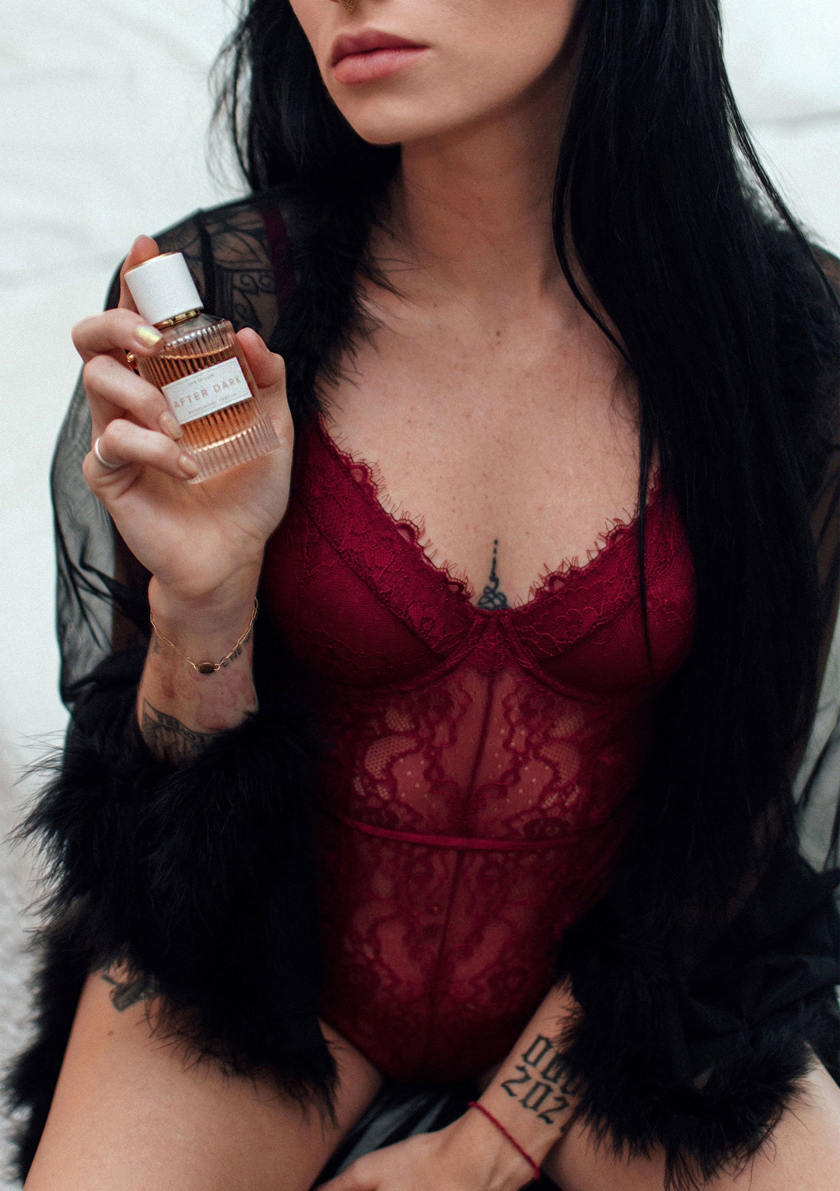 Femme portant de la lingerie et tenant un parfum. Cadeau sensuel et élégant.; Vrouw in lingerie houdt parfum vast. Sensueel en elegant cadeau-idee.; Woman in lingerie holding perfume. Sensual & elegant gift idea.