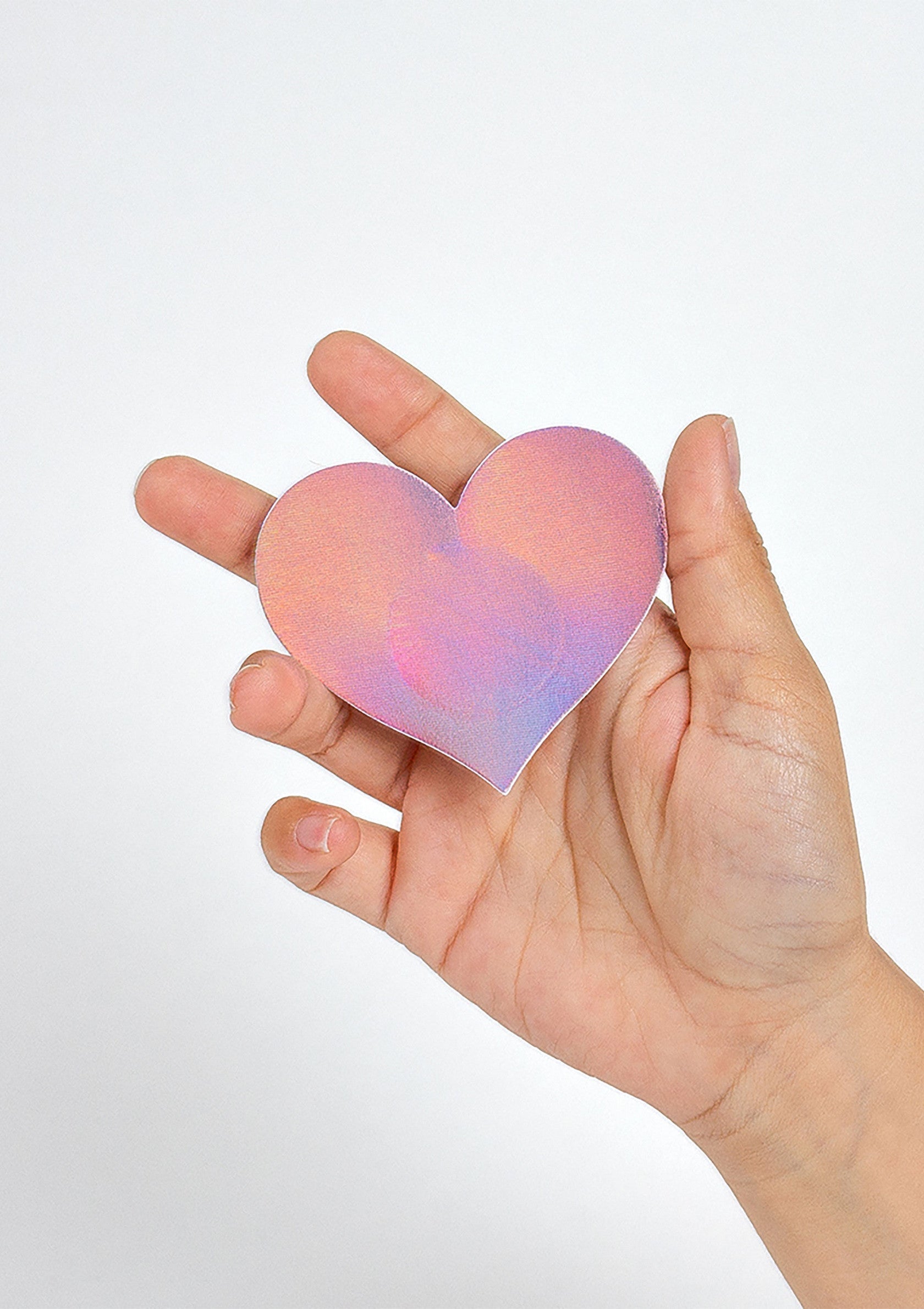Coeur rose et violet irisé dans la main. Parfait pour la Saint-Valentin ou pour décorer vos cadeaux avec amour.; Roze en paars iriserend hart in de hand. Perfect voor Valentijnsdag of om cadeaus liefdevol te versieren.; Pink and purple iridescent heart in hand. Perfect for Valentine's Day or decorating gifts with love.
