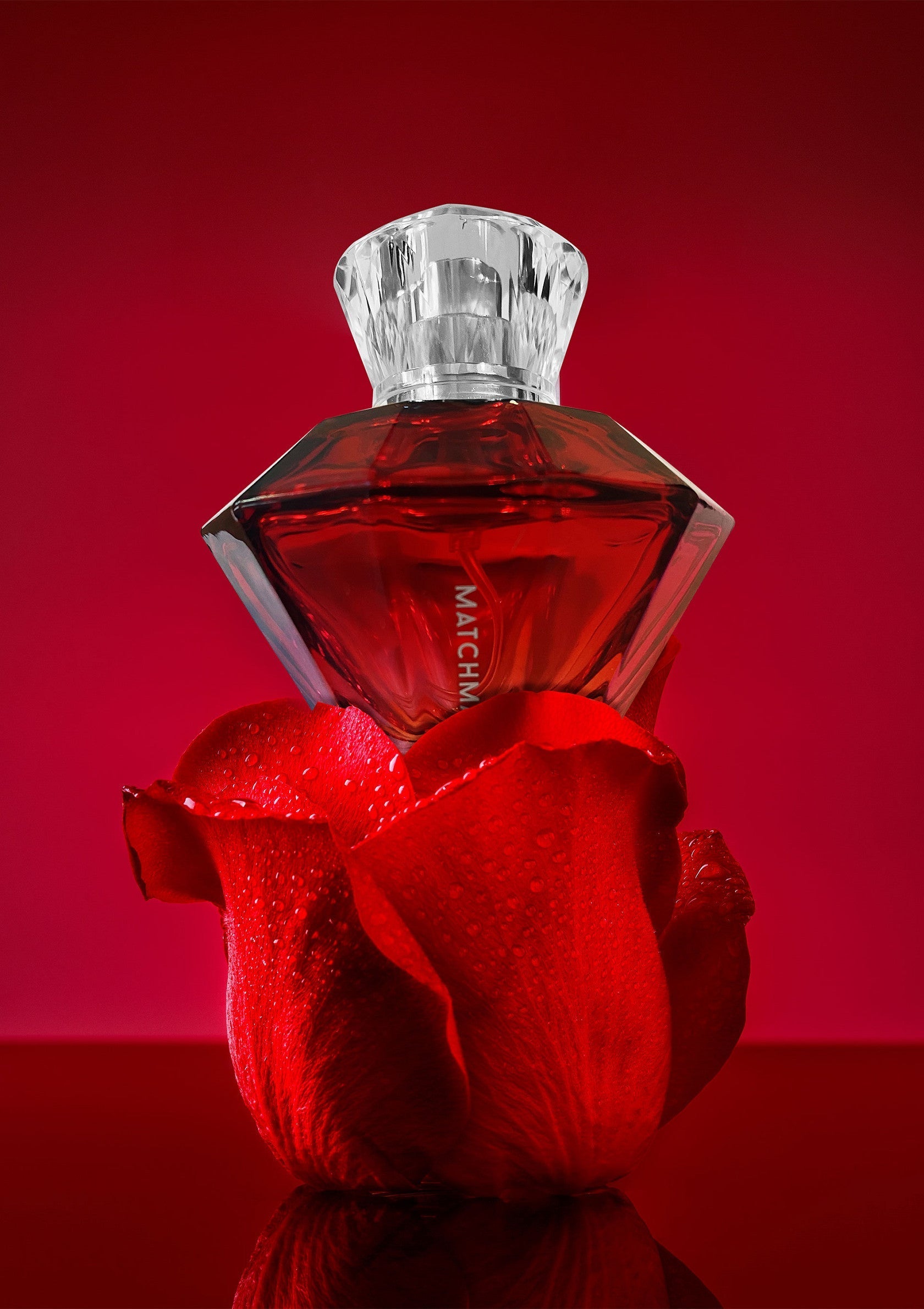 Parfum floral rouge intense. Élégance et sensualité. Bouteille de luxe sur une rose rouge. Fragrance captivante.; Intense rode bloemige parfum. Elegantie en sensualiteit. Luxe fles op een rode roos. Boeiende geur.; Intense red floral perfume. Elegance and sensuality. Luxury bottle on a red rose. Captivating fragrance.