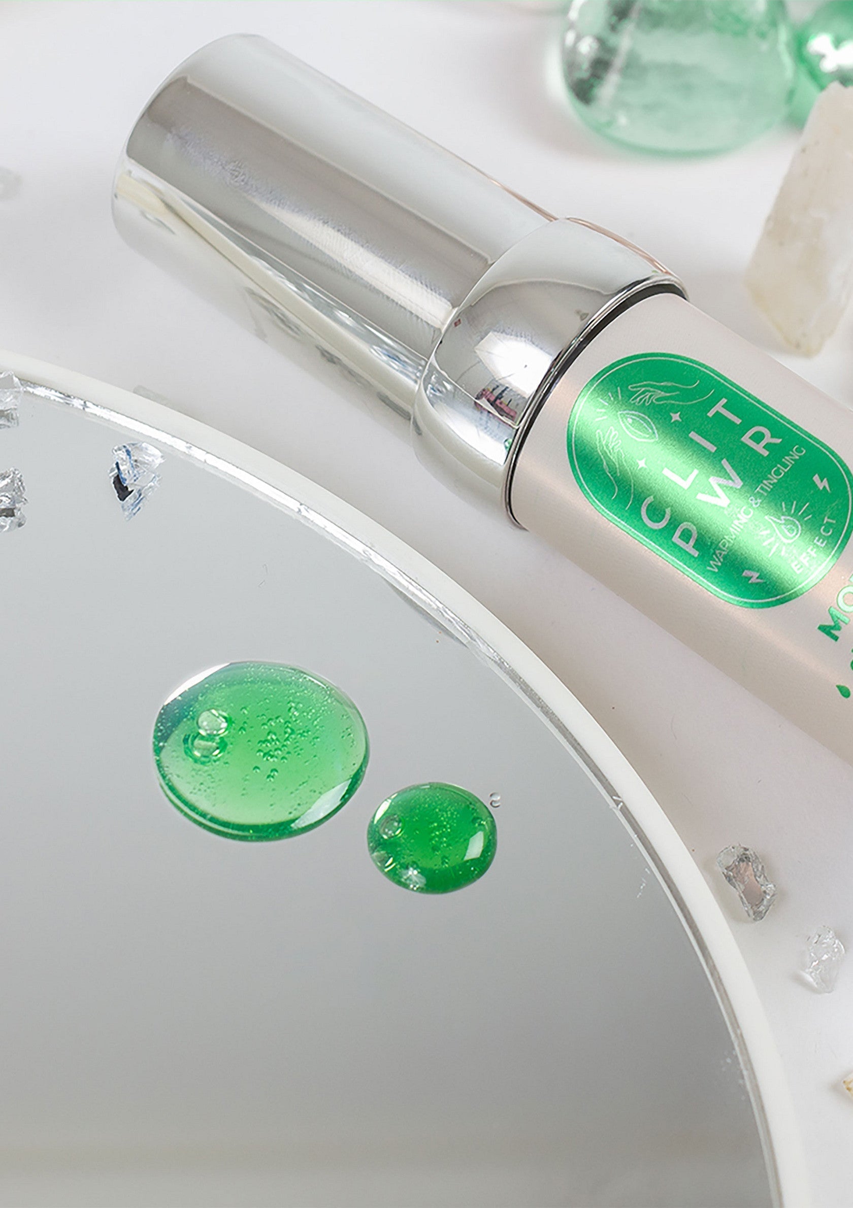 Sérum visage 'Power Potion' éclaircissant, avec gouttes vertes sur miroir. Soin de la peau pour un teint éclatant et uniforme.; Gezichtsserum 'Power Potion' verhelderend, met groene druppels op spiegel. Huidverzorging voor een stralende en egale teint.; Brightening 'Power Potion' face serum with green drops on mirror. Skincare for radiant and even skin tone.