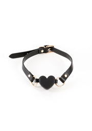 Collier en cuir noir avec un pendentif en forme de cœur pour une touche séduisante.; Zwarte leren choker met hartvormige hanger voor een verleidelijke touch.; Black leather choker with a heart pendant for a seductive touch.