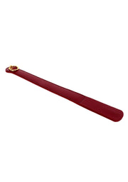 Chausse-pied rouge bordeaux avec anneau doré. Facilite l'enfilage des chaussures avec élégance.; Bordeauxrode schoenlepel met gouden ring. Maakt het aantrekken van schoenen elegant en gemakkelijk.; Burgundy red shoehorn with gold ring. Makes putting on shoes elegant and easy.