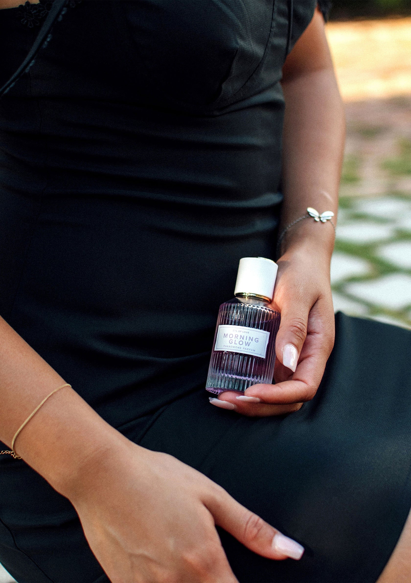 Flacon de parfum 'Morning Glow' présenté par une femme élégante. Découvrez notre collection de parfums de luxe.; Fles 'Morning Glow' parfum gepresenteerd door een elegante vrouw. Ontdek onze luxe parfumcollectie.; Elegant woman showcasing 'Morning Glow' perfume bottle. Explore our collection of luxury fragrances.