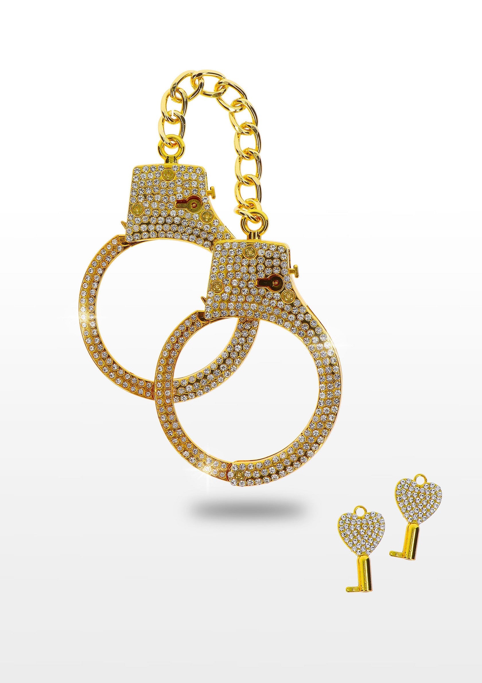 Menottes dorées et clés en forme de cœur scintillantes pour pimenter votre vie amoureuse.; Gouden handboeien en fonkelende sleutels in hartvorm om je liefdesleven wat pit te geven.; Gold handcuffs and sparkling heart-shaped keys to spice up your love life.