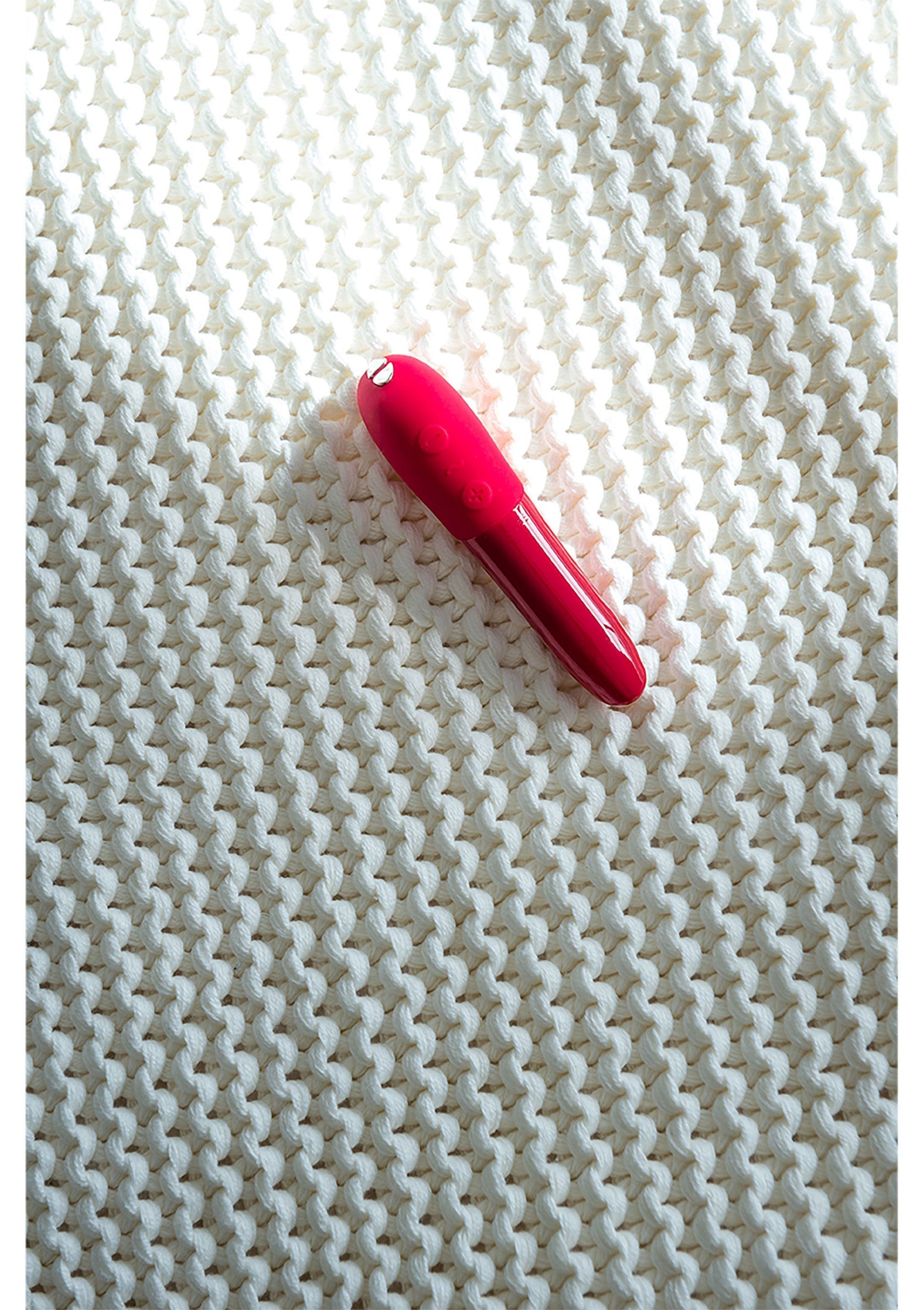 Vibromasseur rouge élégant sur un textile blanc texturé. Plaisir et sensualité garantis. Découvrez notre collection !; Elegante rode vibrator op een wit, gestructureerd textiel. Gegarandeerd plezier en sensualiteit. Bekijk onze collectie!; Elegant red vibrator on a textured white textile. Pleasure and sensuality guaranteed. Discover our collection!