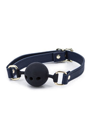 Bâillon de bouche noir avec sangle bleu marine et accents dorés.; Zwarte knevel met marineblauwe band en gouden accenten.; Black ball gag with navy strap and gold accents.