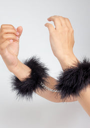 Manchettes en plumes noires avec chaîne argentée. Accessoires de mode sensuels et élégants.; Zwarte veren manchetten met zilveren ketting. Sensuele en elegante modeaccessoires.; Black feather cuffs with silver chain. Sensual and elegant fashion accessories.