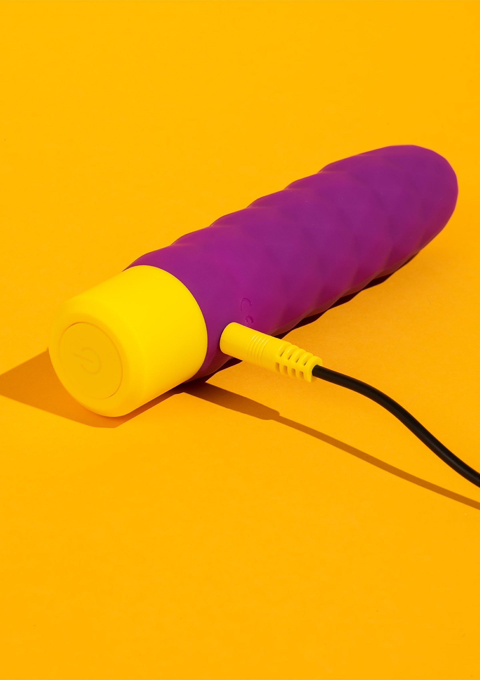 Vibromasseur rechargeable violet et jaune pour le plaisir personnel.; Oplaadbare vibrator in paars en geel voor persoonlijk plezier.; Rechargeable vibrator in purple and yellow for personal pleasure.