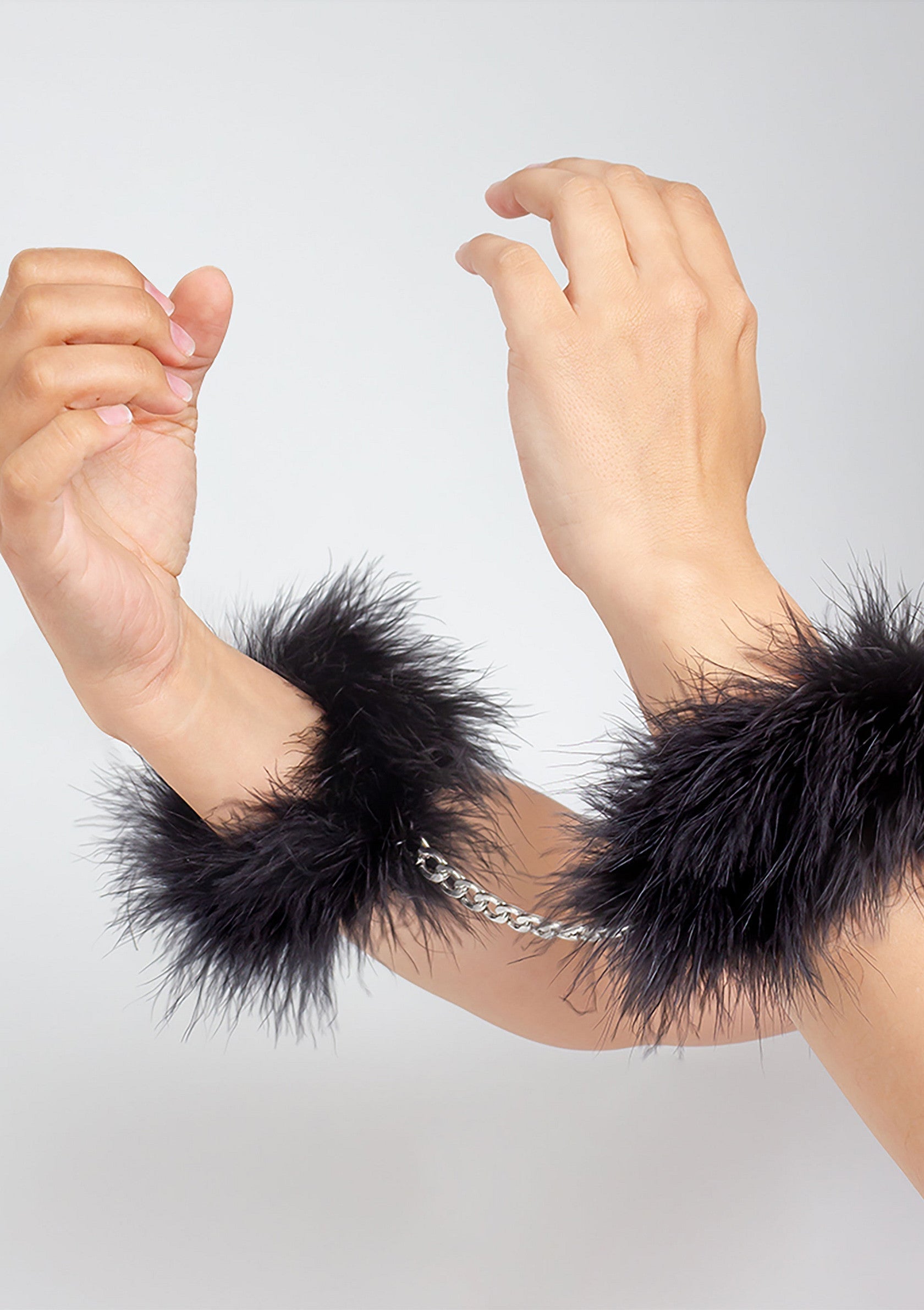 Manchettes en plumes noires avec chaîne argentée. Accessoires de mode sensuels et élégants.; Zwarte veren manchetten met zilveren ketting. Sensuele en elegante modeaccessoires.; Black feather cuffs with silver chain. Sensual and elegant fashion accessories.
