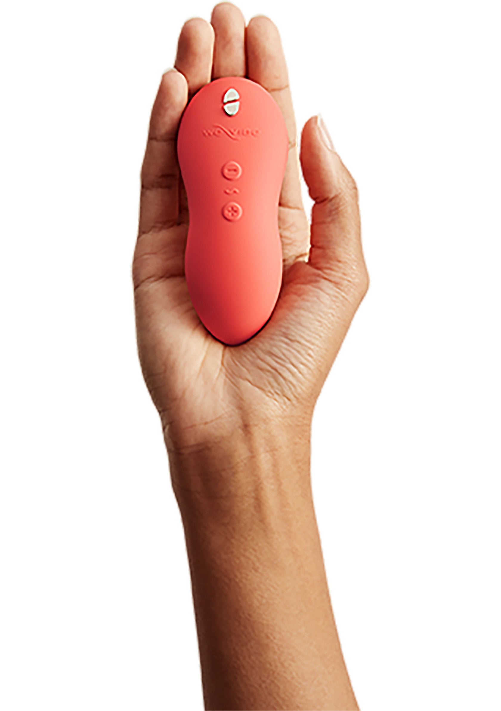 Vibrateur corail dans la main, plaisir intime discret et élégant.; Koraalkleurige vibrator in hand, voor discreet en stijlvol intiem genot.; Coral vibrator in hand, for discreet and stylish intimate pleasure.